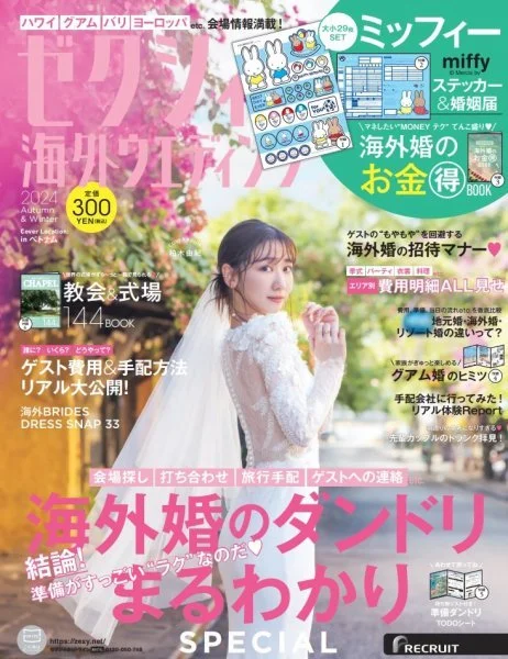日本の女性が白いレースのドレスを着て、桜の木の下で写真を撮影している雑誌の表紙。色とりどりの文字と小さなイラスト、広告が散りばめられている。