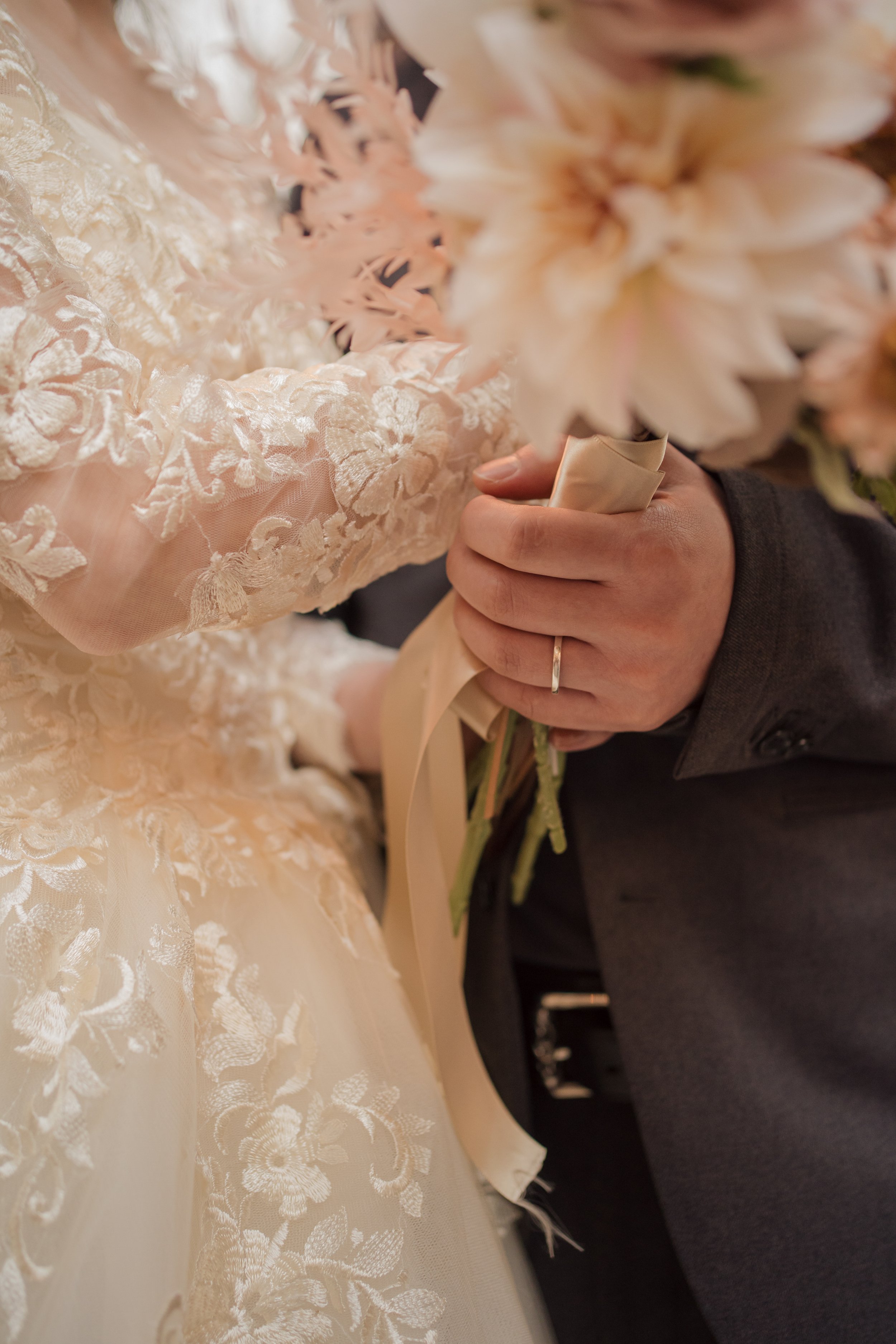 結婚式の新郎と新婦が花束を持ちながら抱き合っている場面