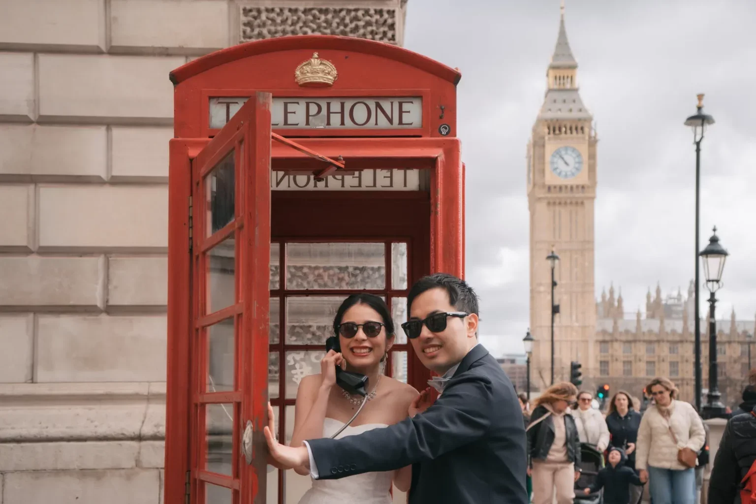 ロンドンのビッグベンとレッド電話ボックスの前で笑顔のカップル