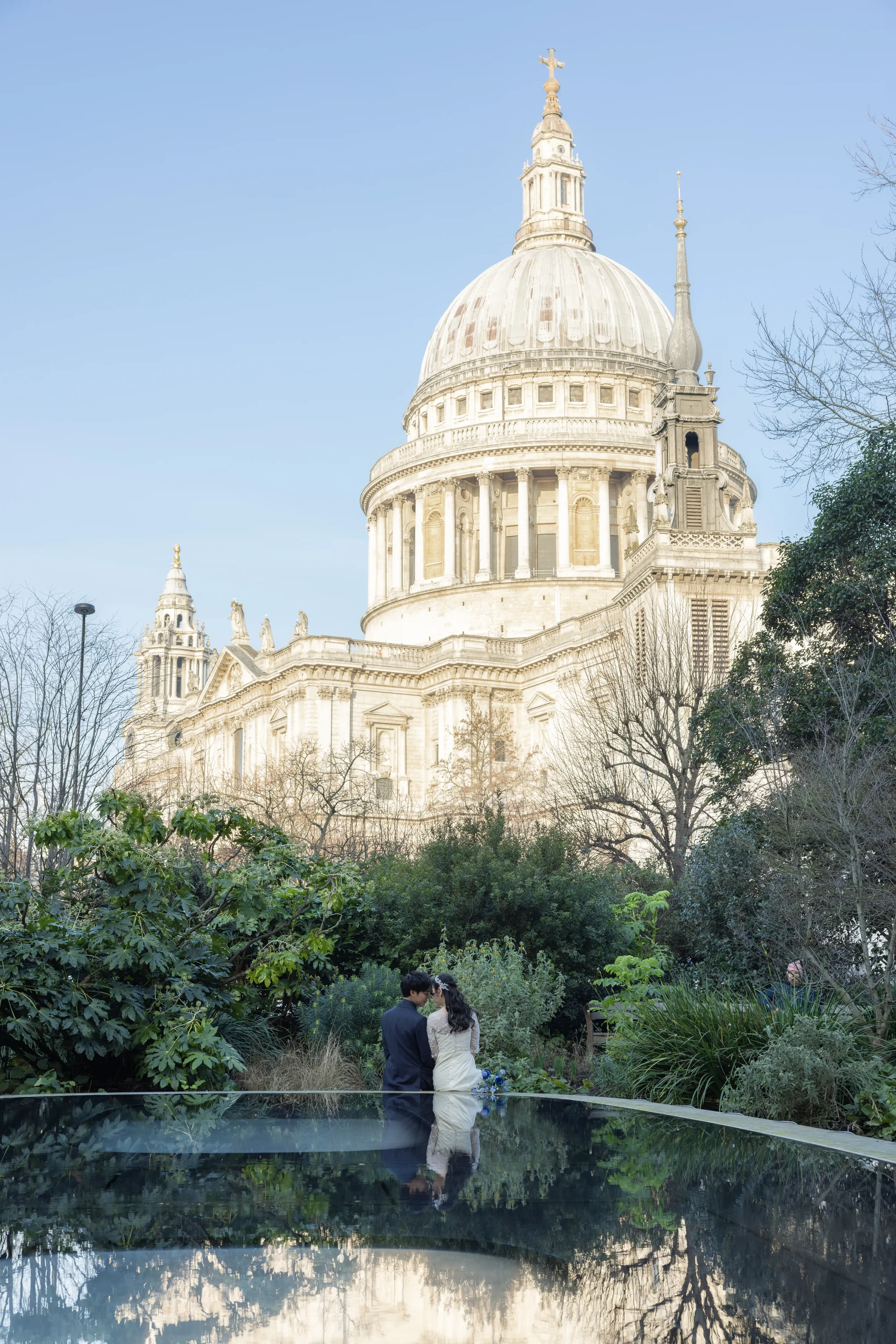 ロンドンのセント・ポール大聖堂の前で結婚式を挙げている新郎新婦。