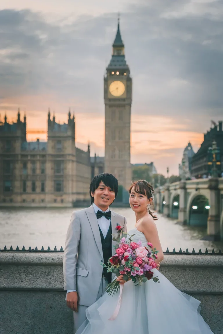 結婚式のカップルがハッピーに微笑みながら写真を撮っている。背景にビッグベンとロンドンの風景。