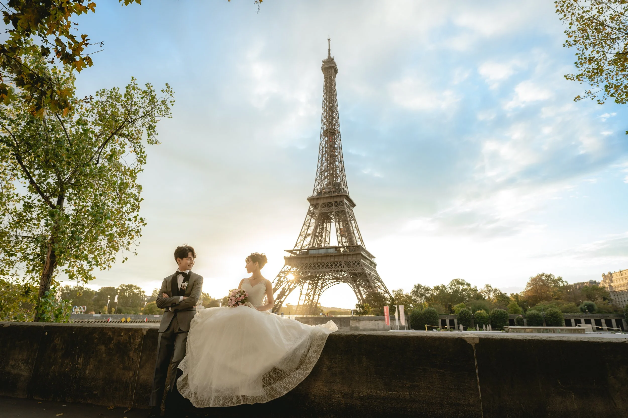 パリのエッフェル塔の前で、新郎新婦が写真を撮っている。