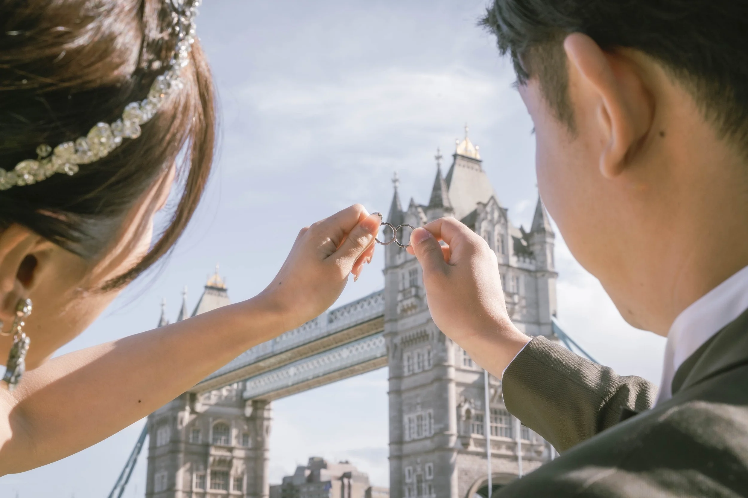 結婚したカップルがロンドン塔の前で結婚指輪を交換している場面