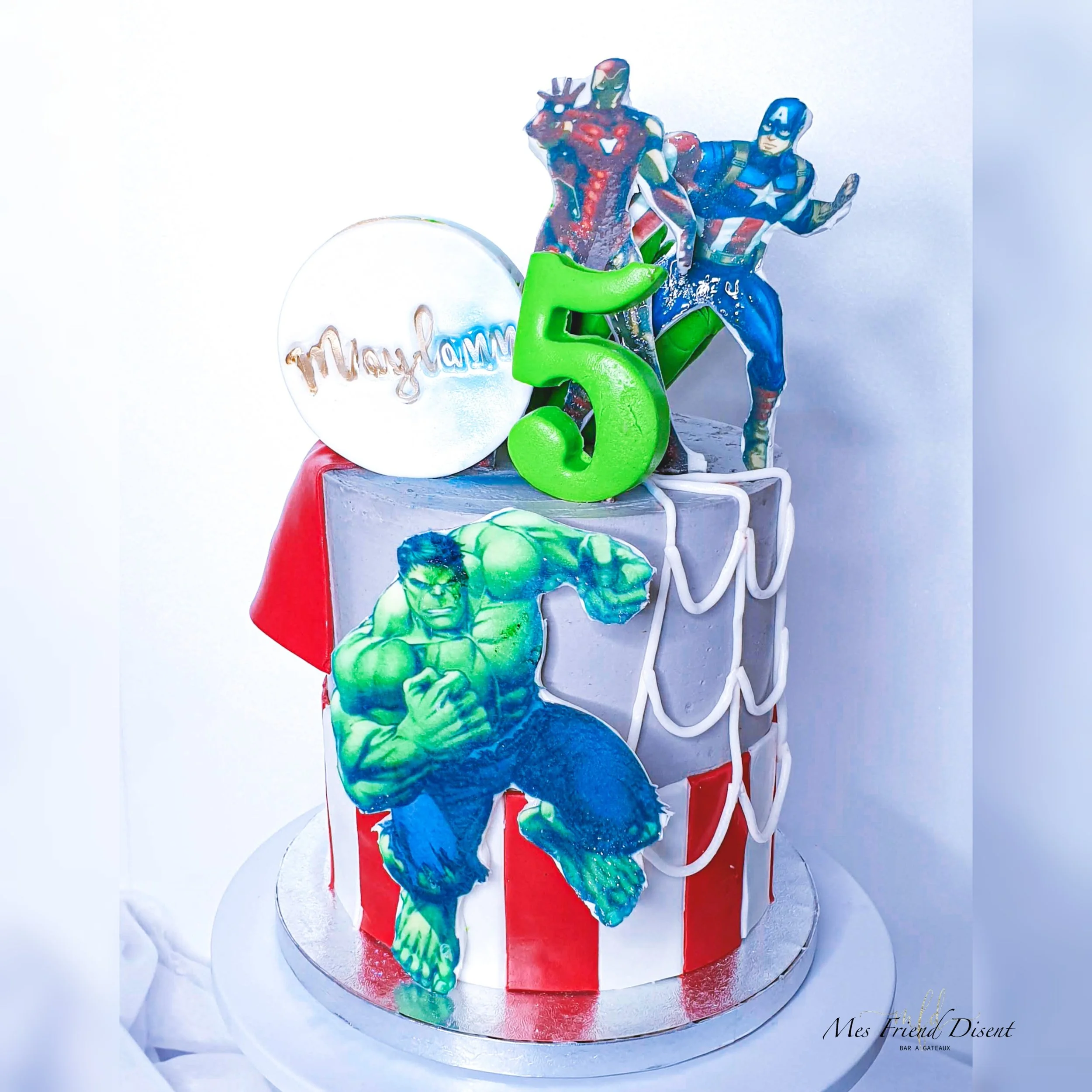 Gâteau d'anniversaire super héros  avec des décorations des Avengers, incluant Hulk, Iron Man et Captain America, et un chiffre 5 vert.