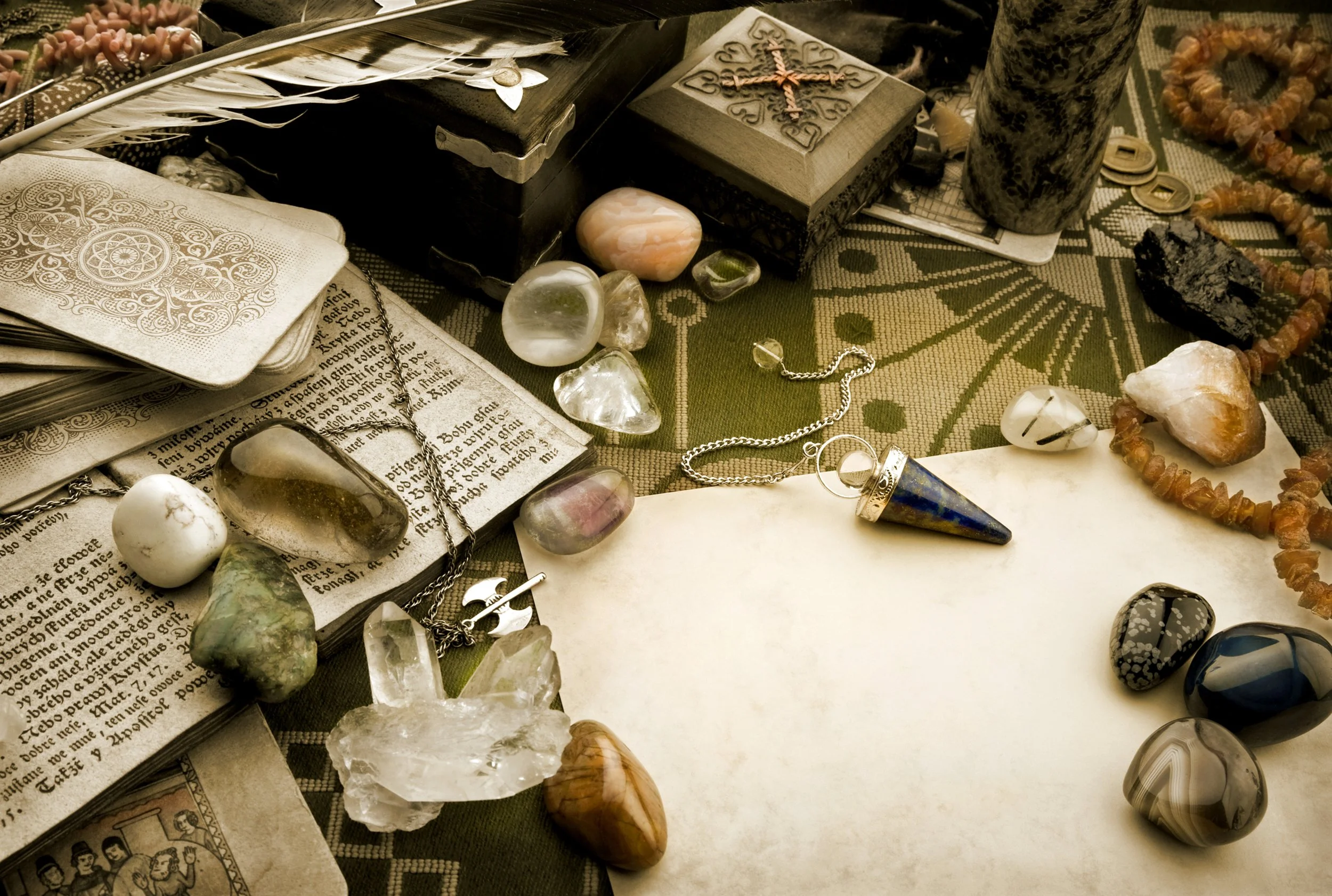 A still life of an old empty piece of paper surrounded by a variety of objects: stones, cards, keys....