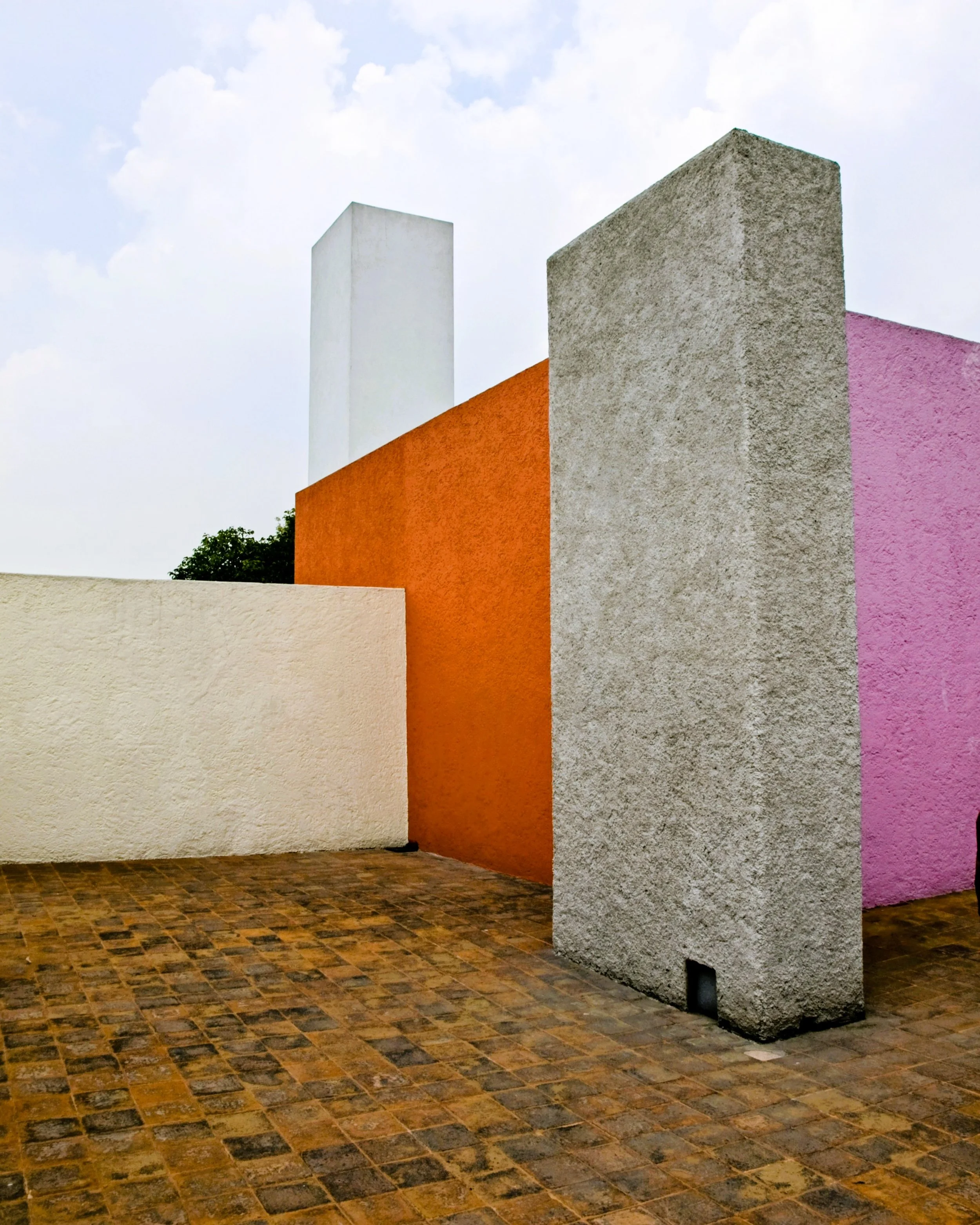 Roof terrace of Luis Barragán's House and Studio in Mexico City, where textured plaster walls, geometric forms, and vibrant color transform the restrained language of Modernism into a deeply personal architectural expression.