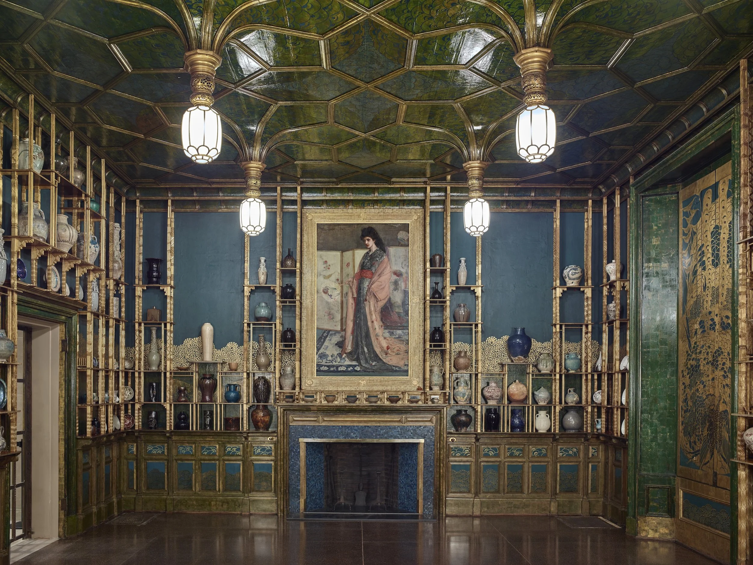 Elaborate room in blue green with gold accents; ceiling of stylized Gothic vaults;  walls holding a quantity of Oriental ceramics within specially designed shelves;  the centerpiece -- a painting of a woman in Japanese garb and setting