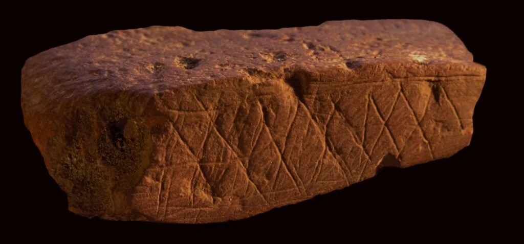 Three-inch piece of red ochre with continuous, incised, X shaped pattern, dating from c. 90,000 BCE, found at Klaises River Cave, South Africa.