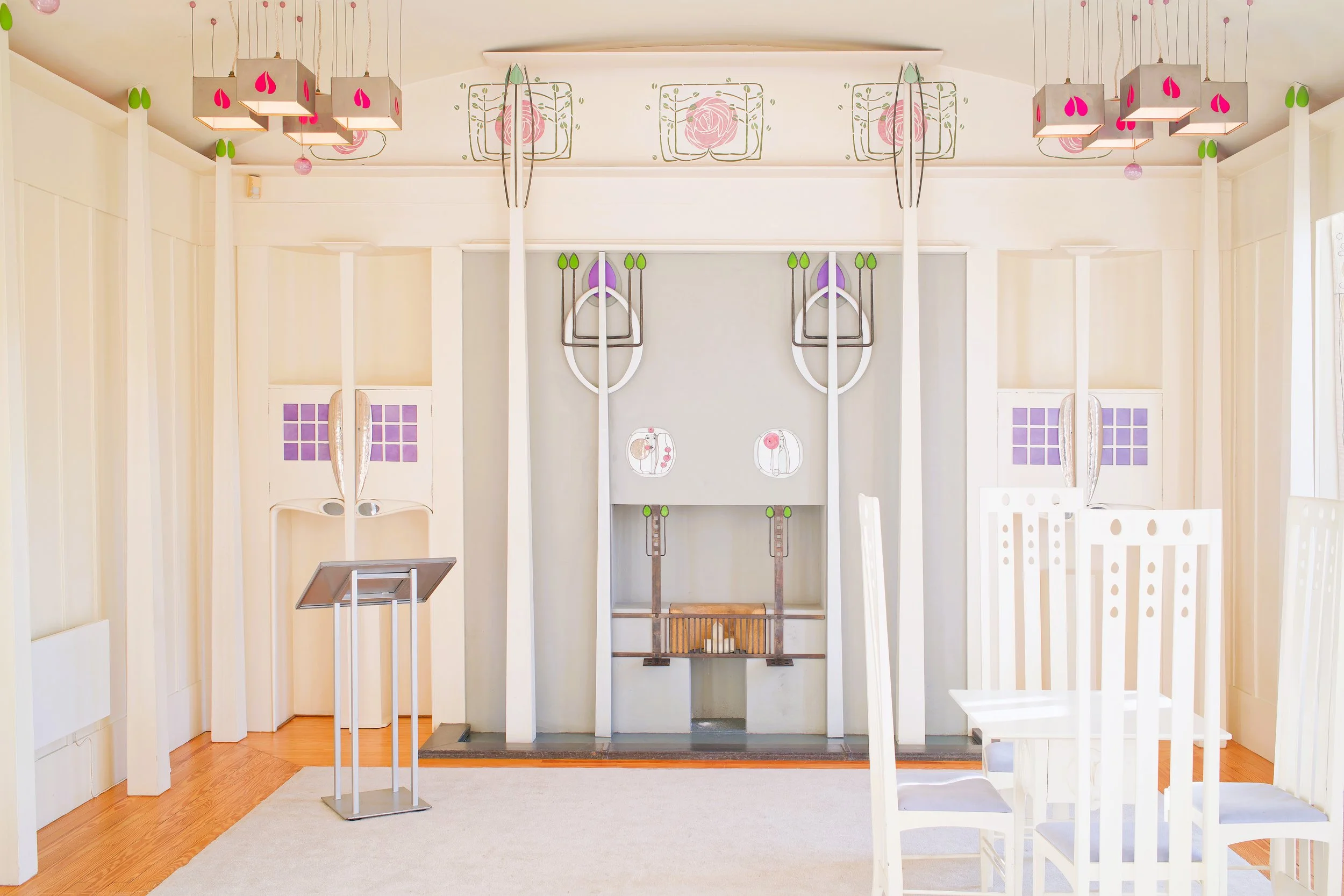 a very unconventional church interior, all white with any slender vertical elements, accented here and there with artistic stylized stencils of roses