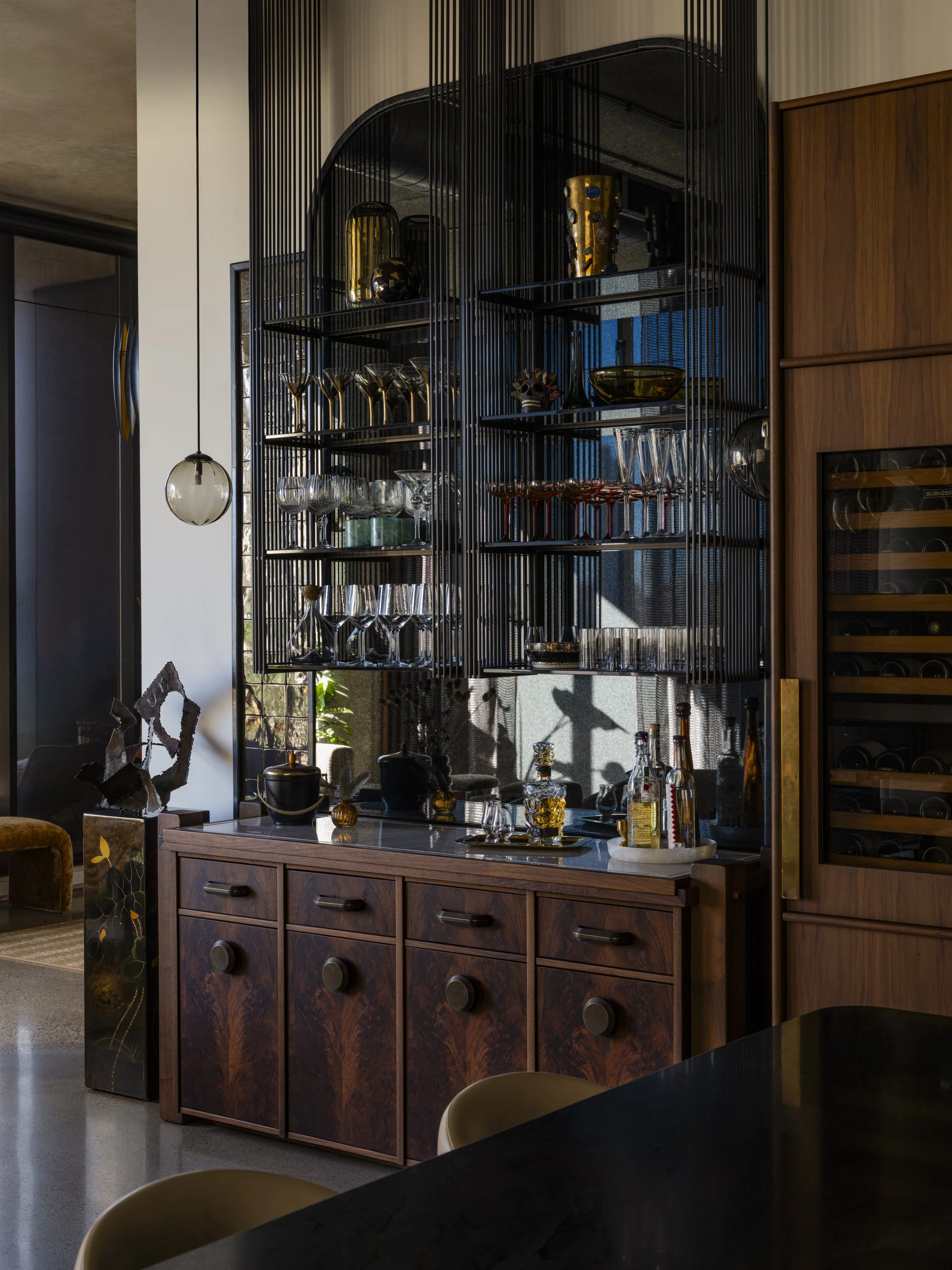 Bar cabinet with glassware and liquor bottles in a modern living space