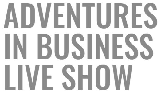 Text reading 'Adventures in Business Live Show' in gray letters on a white background.