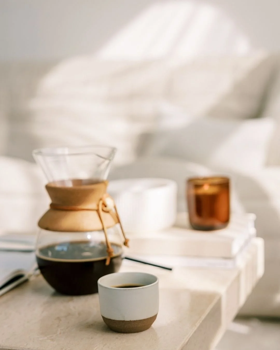 Minimal coffee setup on a table beside a notepad, representing a calm, conversational approach to answering client social media FAQs at Aviso Studios.