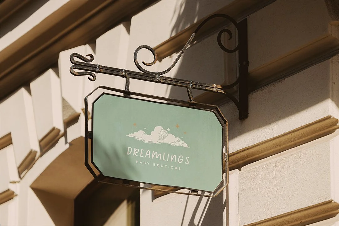 Baby boutique storefront sign with soft sage branding and illustrated cloud design.