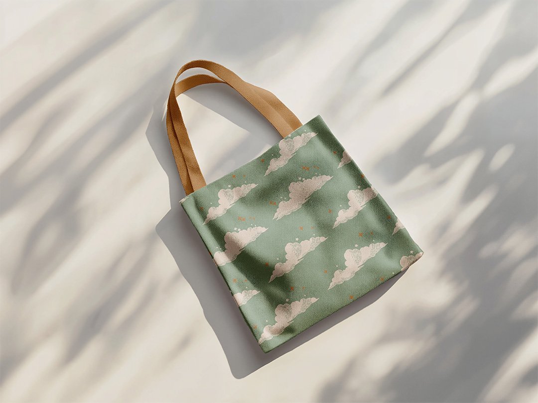 Branded tote bag for a children’s clothing boutique with soft cloud pattern on sage green fabric.