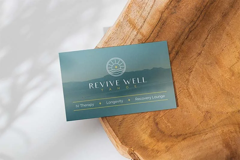 Minimal wellness brand business card on a wooden tray, showing nature-inspired visual identity for a health-focused business.