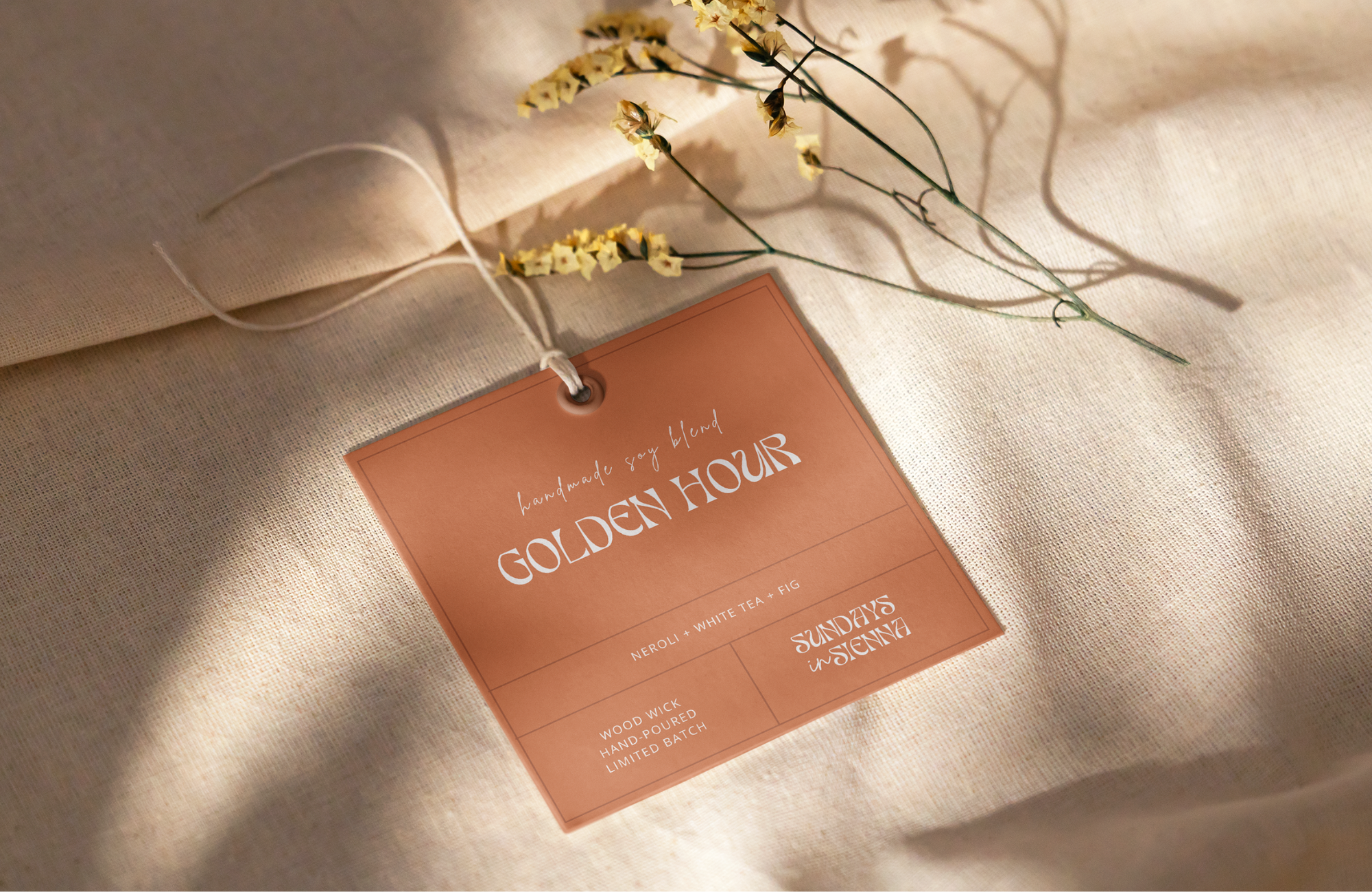 Golden Hour candle hangtag on linen fabric with dried floral styling.