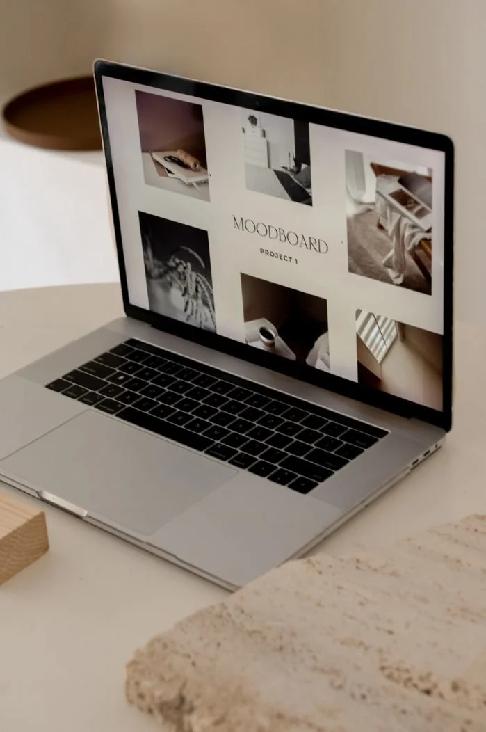 Open MacBook displaying a moodboard titled PROJECT 1 with various images of interior decor and design for a brand identity refresh.
