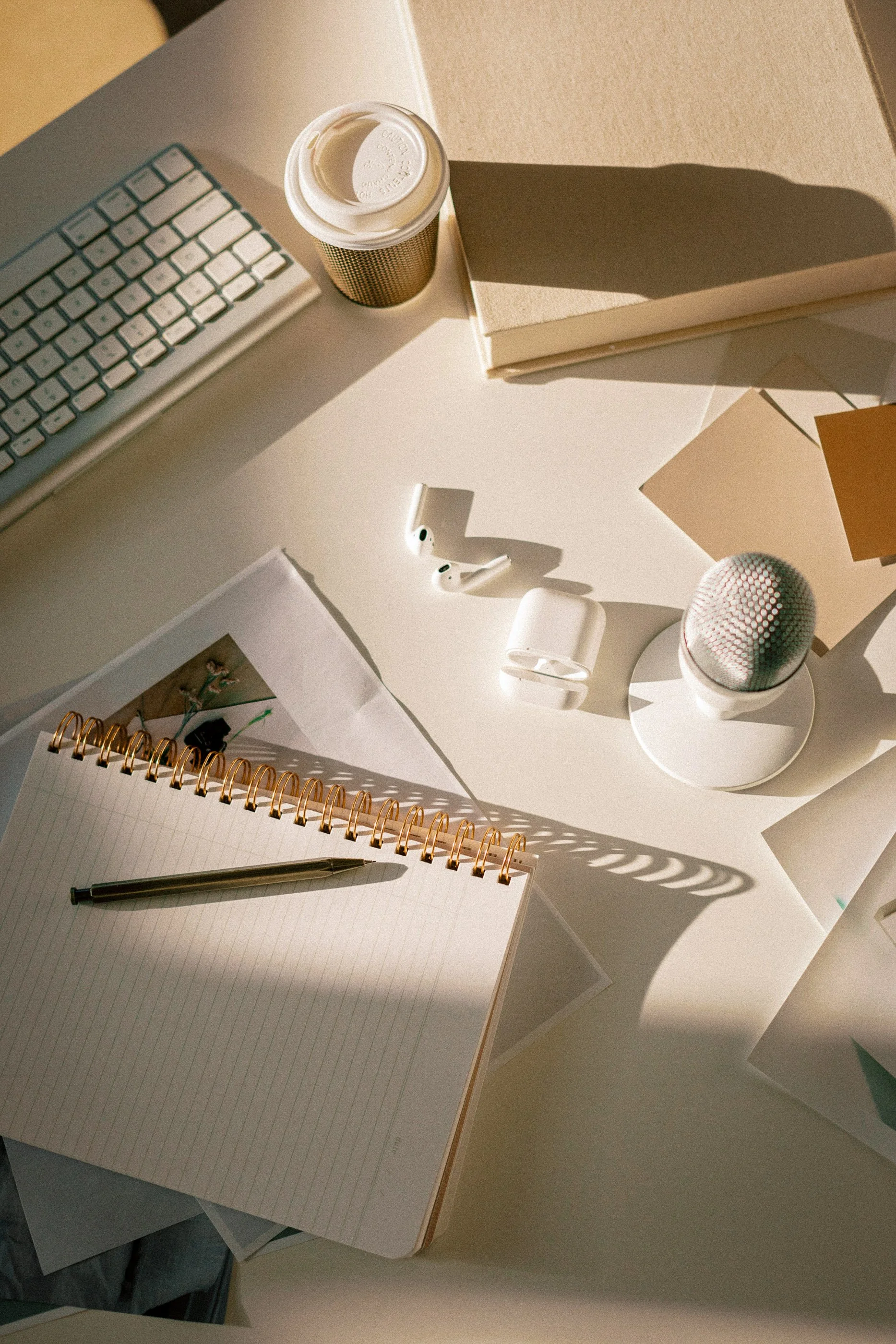 Warm editorial flatlay of a small business workspace with a keyboard, notebook, and microphone, representing branding and website design by Aviso Studios in Santa Cruz, California.