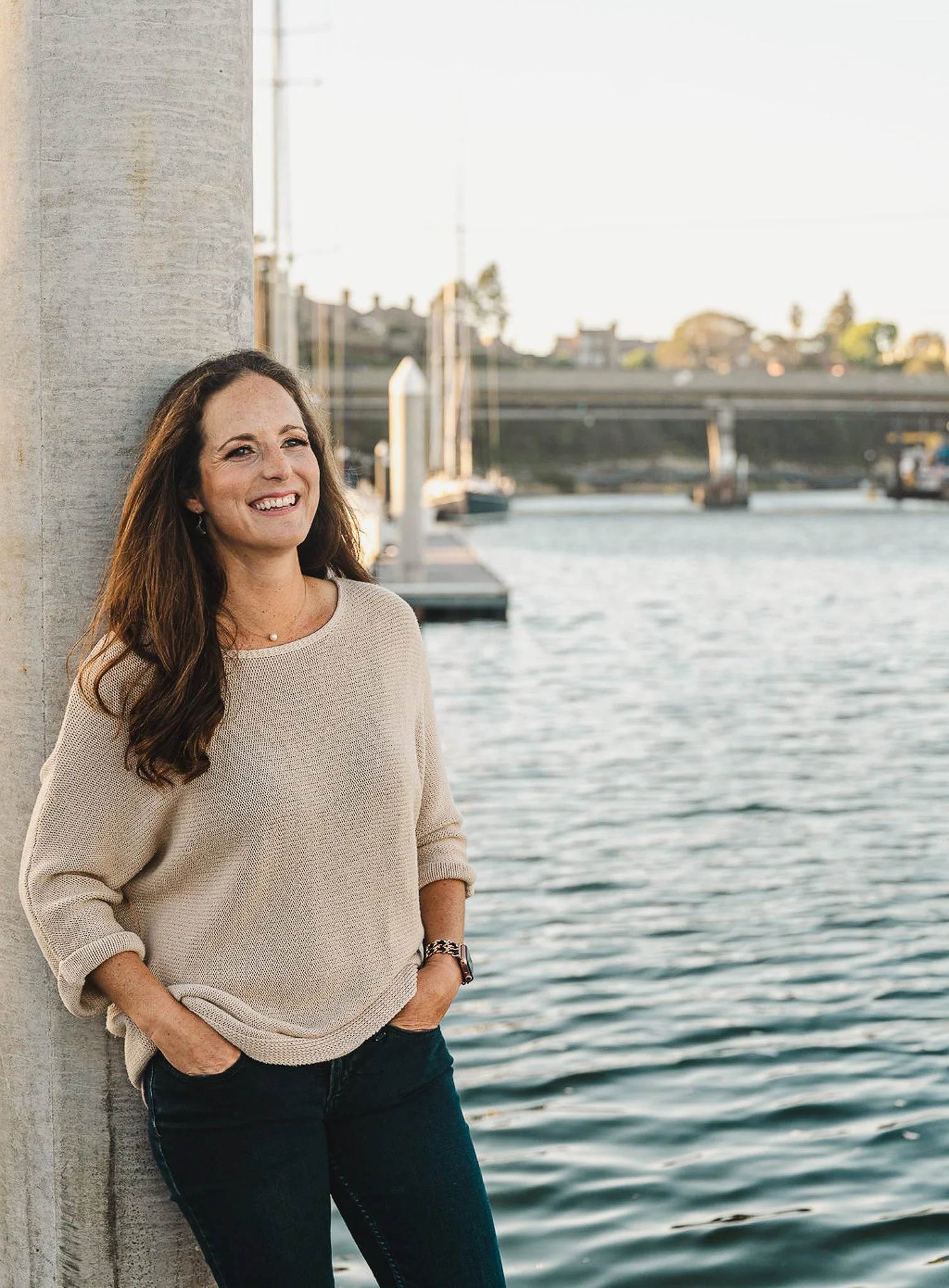 Liz Kroft standing by the Santa Cruz harbor, smiling and approachable as the marketing strategist behind Aviso Studio.