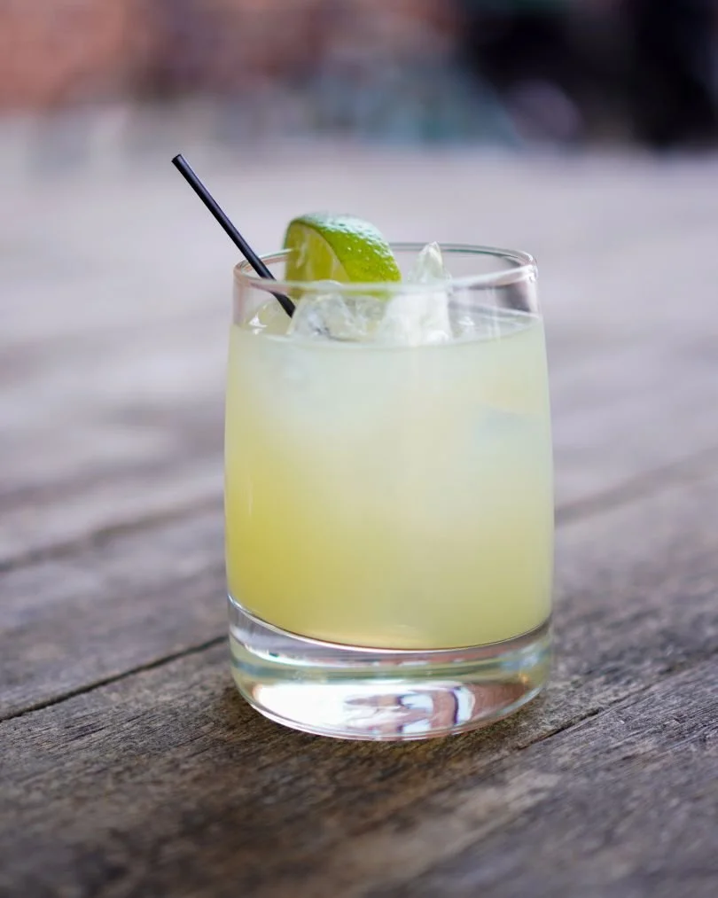 A fresh lime margarita on a wooden table, reflecting a marketing consultant's relaxed, approachable brand personality.