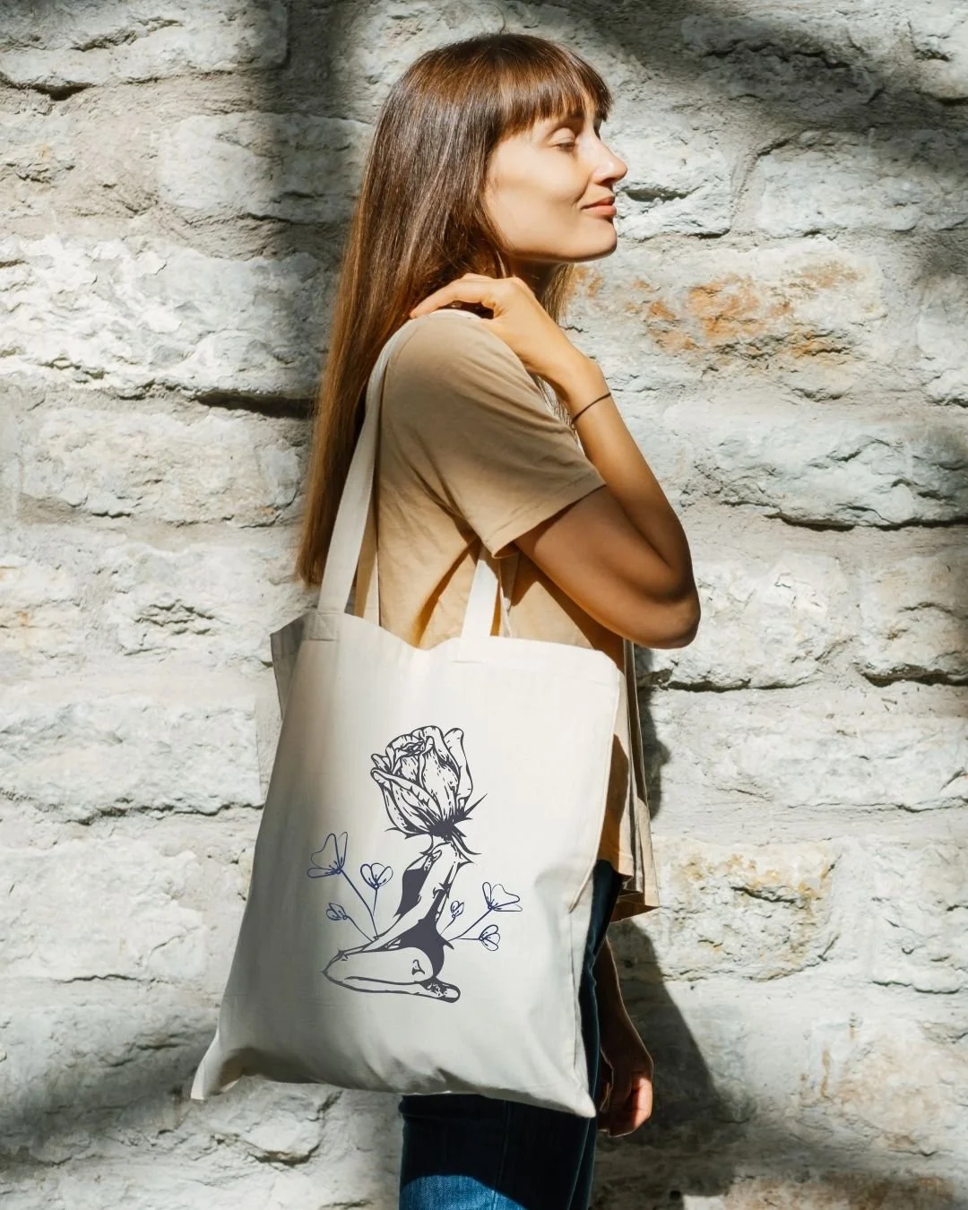woman carrying a canvas bag with the logo design from aviso studios on it for a local candle company