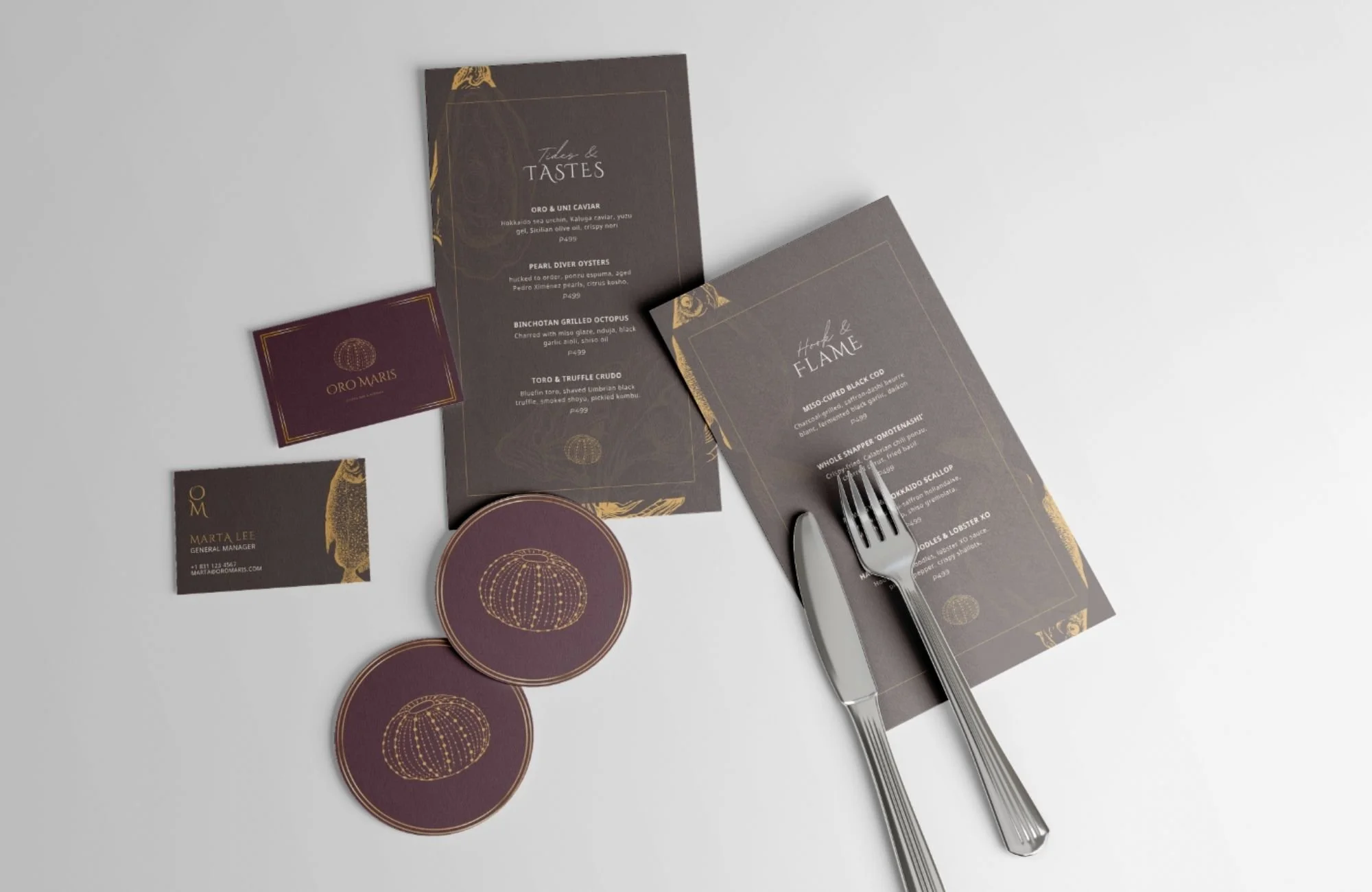Flat lay of custom-designed seafood restaurant branding including menus, coasters, and business cards with rich colors and gold foil accents.
