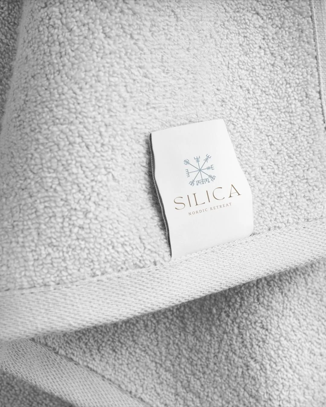 Close-up of the Silica Spa logo embroidered on a plush white towel, representing the brand’s premium touch and attention to detail.