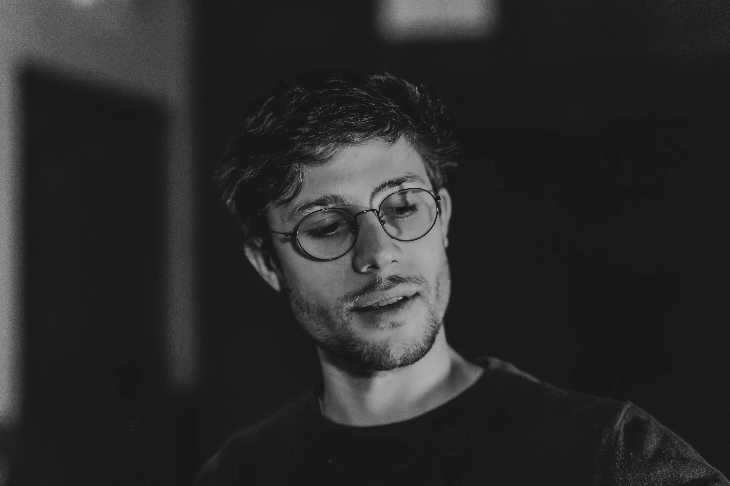 Portrait in black and white of young man wearing glasses.