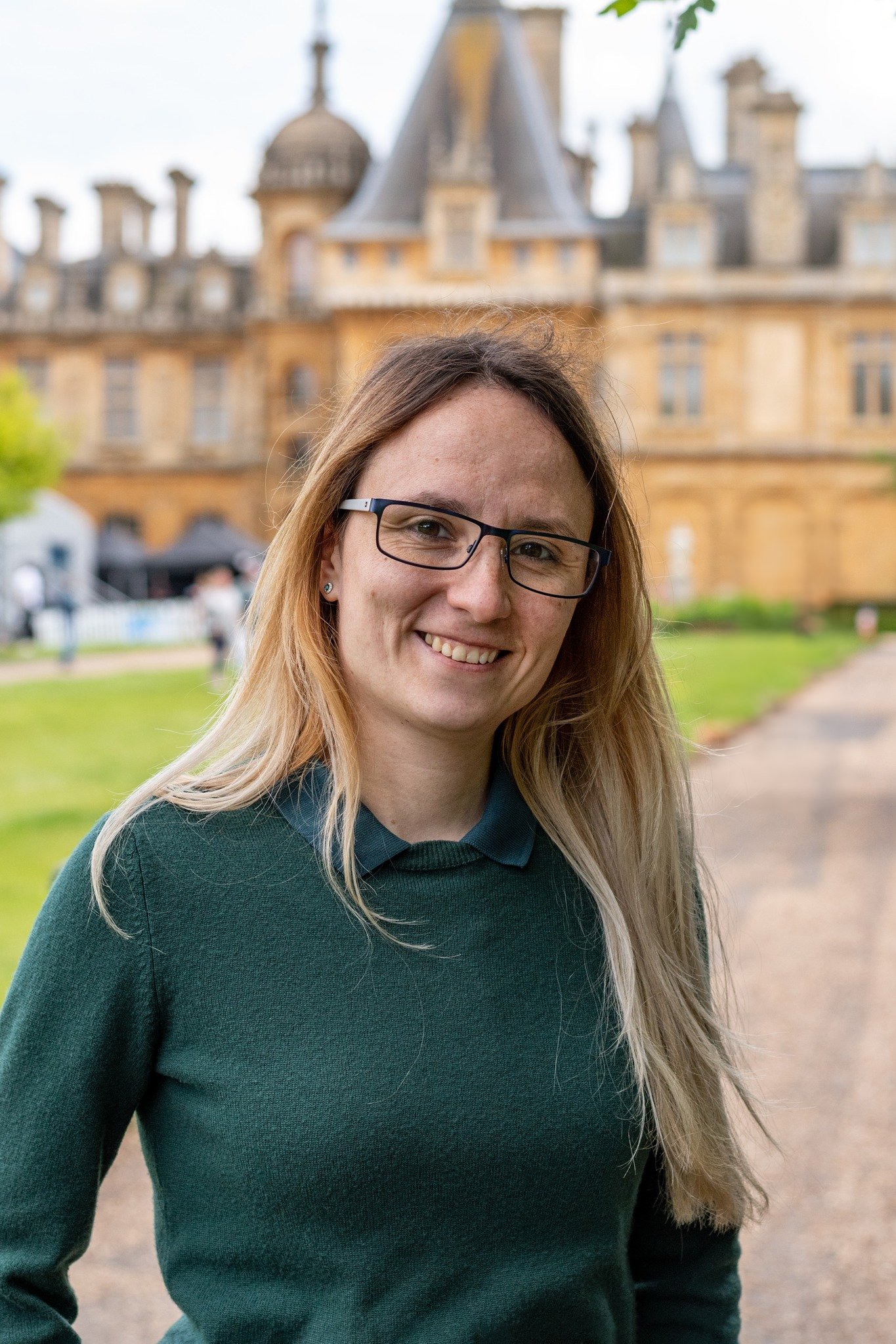 Bálint Barbara, Life, karrier és párkapcsolati coach, szemüveggel, mosolyogva történelmi kastély előtt, zöld pázsittal.