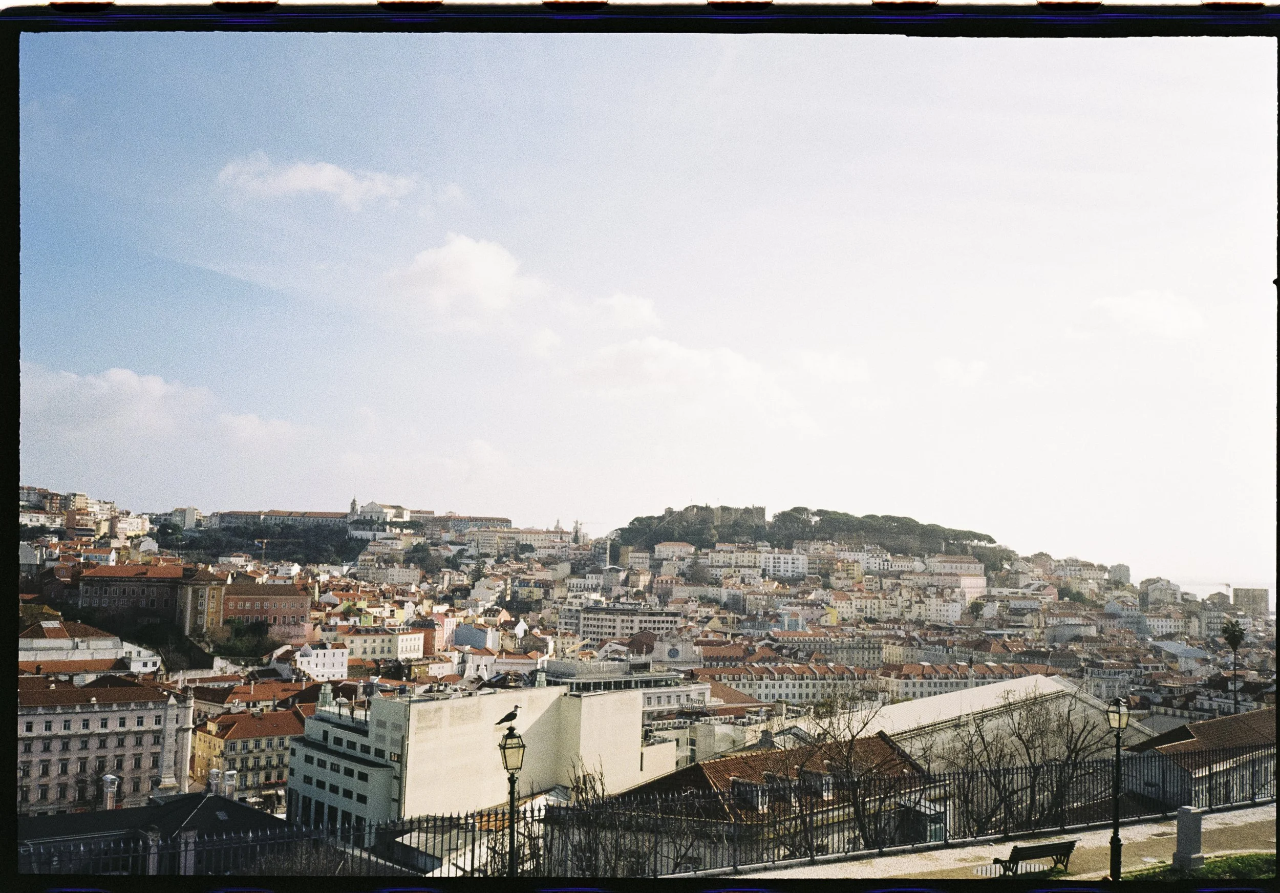 Vista panorámica de los tejados de Lisboa con el castillo de fondo, fotografía analógica