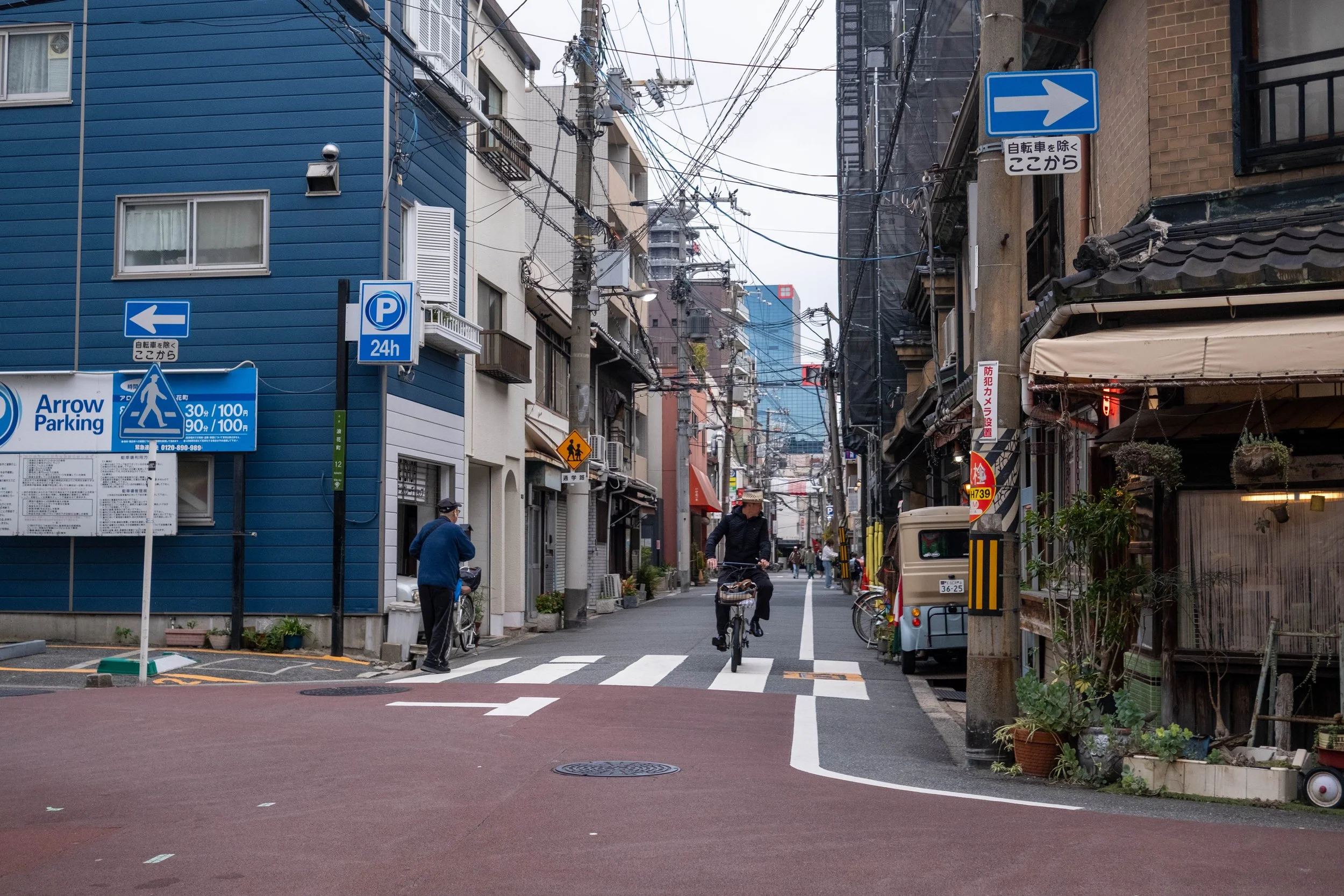 Callejón tranquilo en Osaka con un ciclista, fotografía documental
