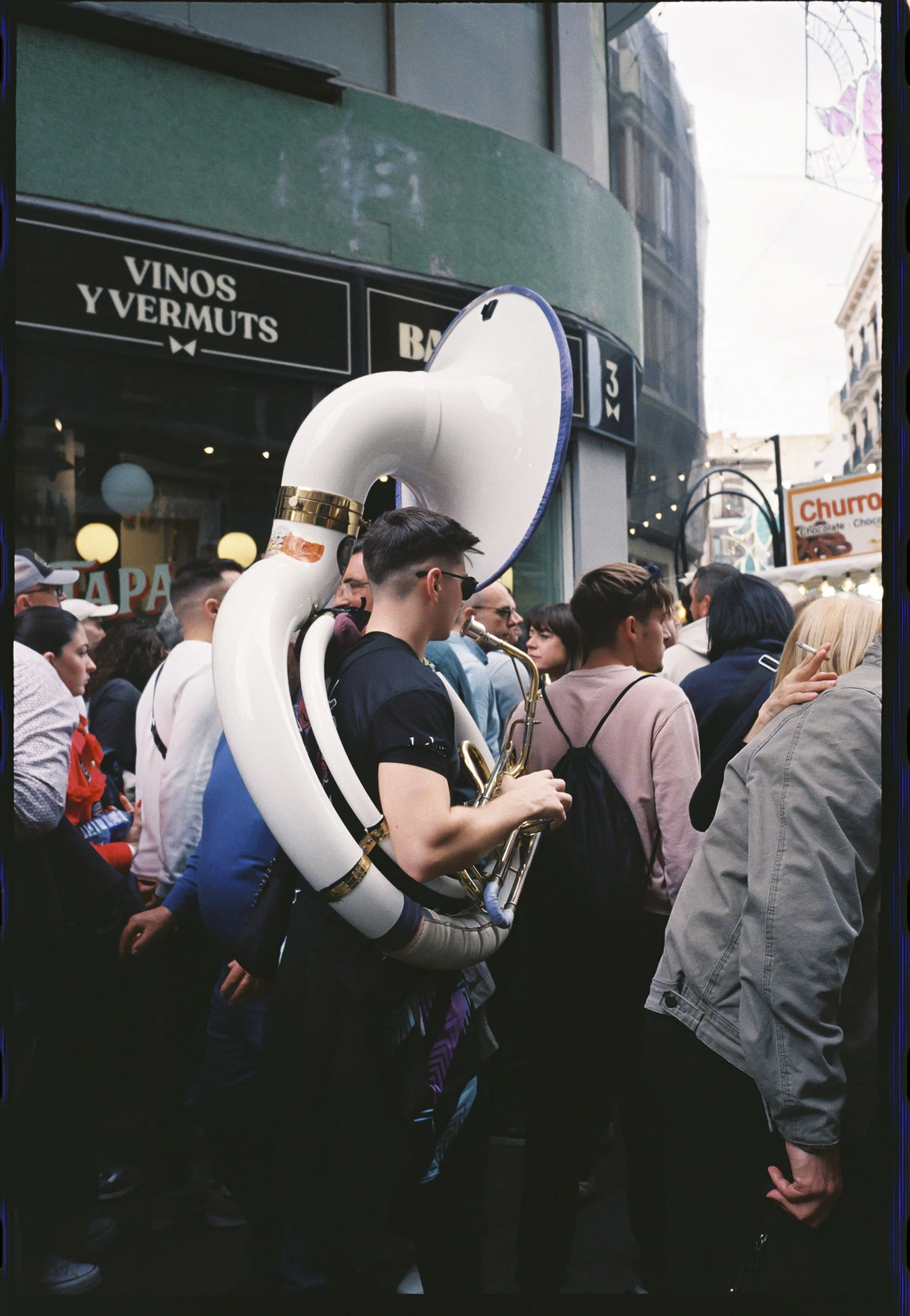 Músico tocando el sousaphone entre la multitud durante las Fallas de Valencia, fotografía analógica
