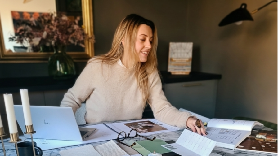 L'architecte d'interieur assise à une table en marbre en train de travailler un projet de décoration
