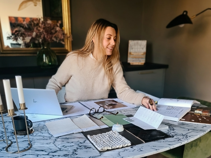 L'architecte d'interieur assise à une table en marbre en train de travailler un projet de décoration