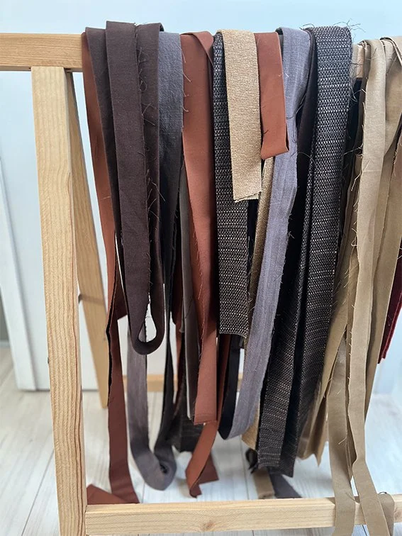 Strikje van verschillende stoffen en texturen, geklemd aan een houten rek