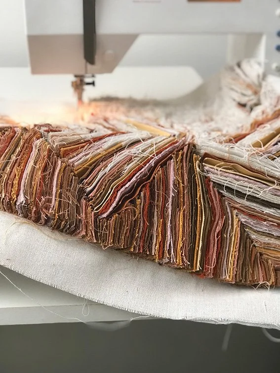 Naaimachine die stof snijdt of plet in een cirkelvormig patroon met verschillende gekleurde stoffen en garen.