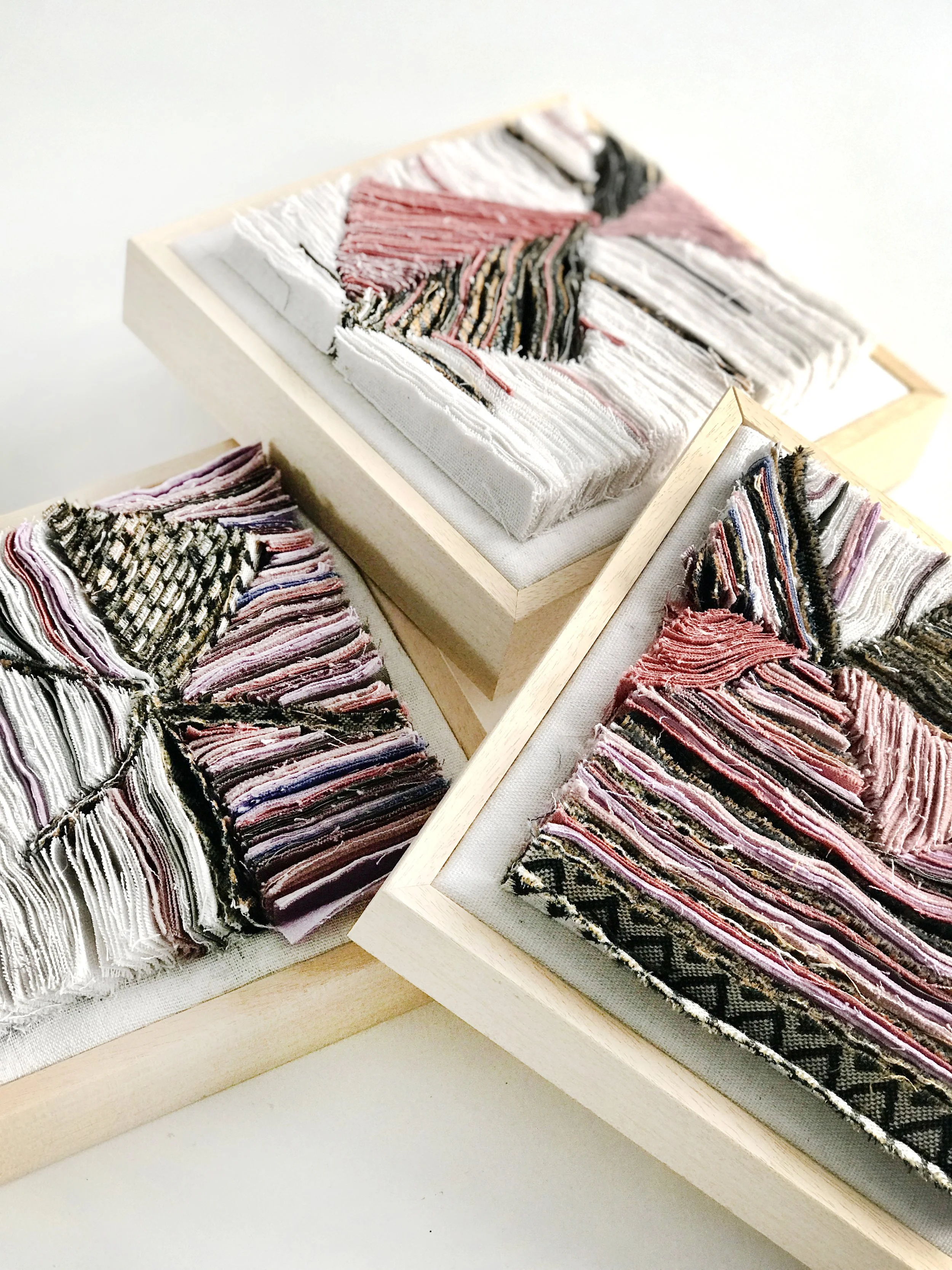 Verschillende textielstalen in houten kaders