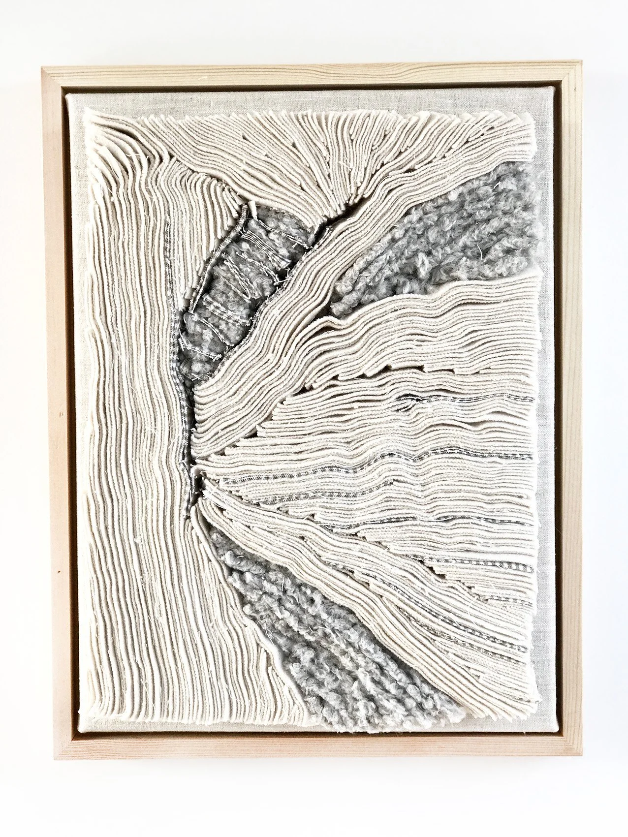 Mixed media kunstwerk met geregen, gevlochten en geknoopte stoffen en vezels in een houten frame.