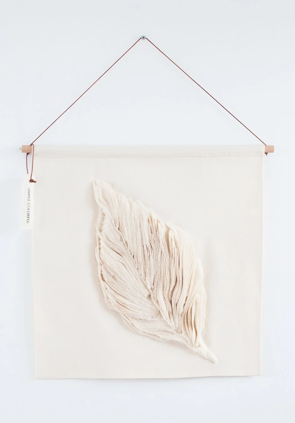 Wit wanddecoratie met een driedimensionale cremekleurige bladvorm