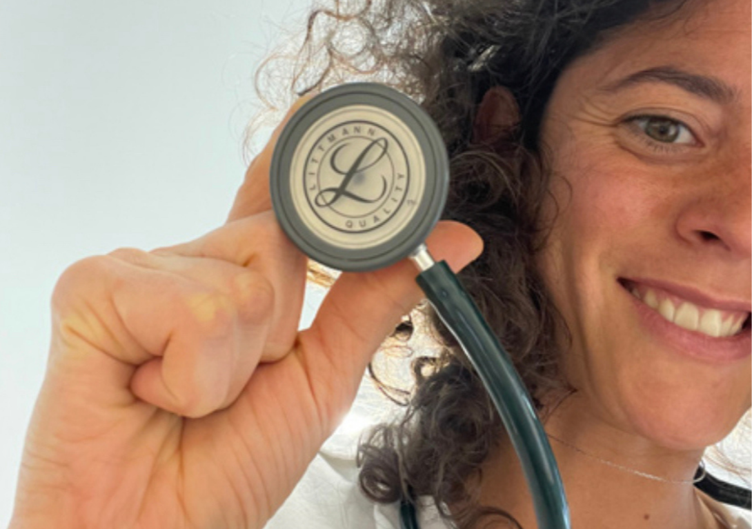 Mujer sonriendo sosteniendo un estetoscopio con un logo que dice 'L' y 'City' en un fondo claro.