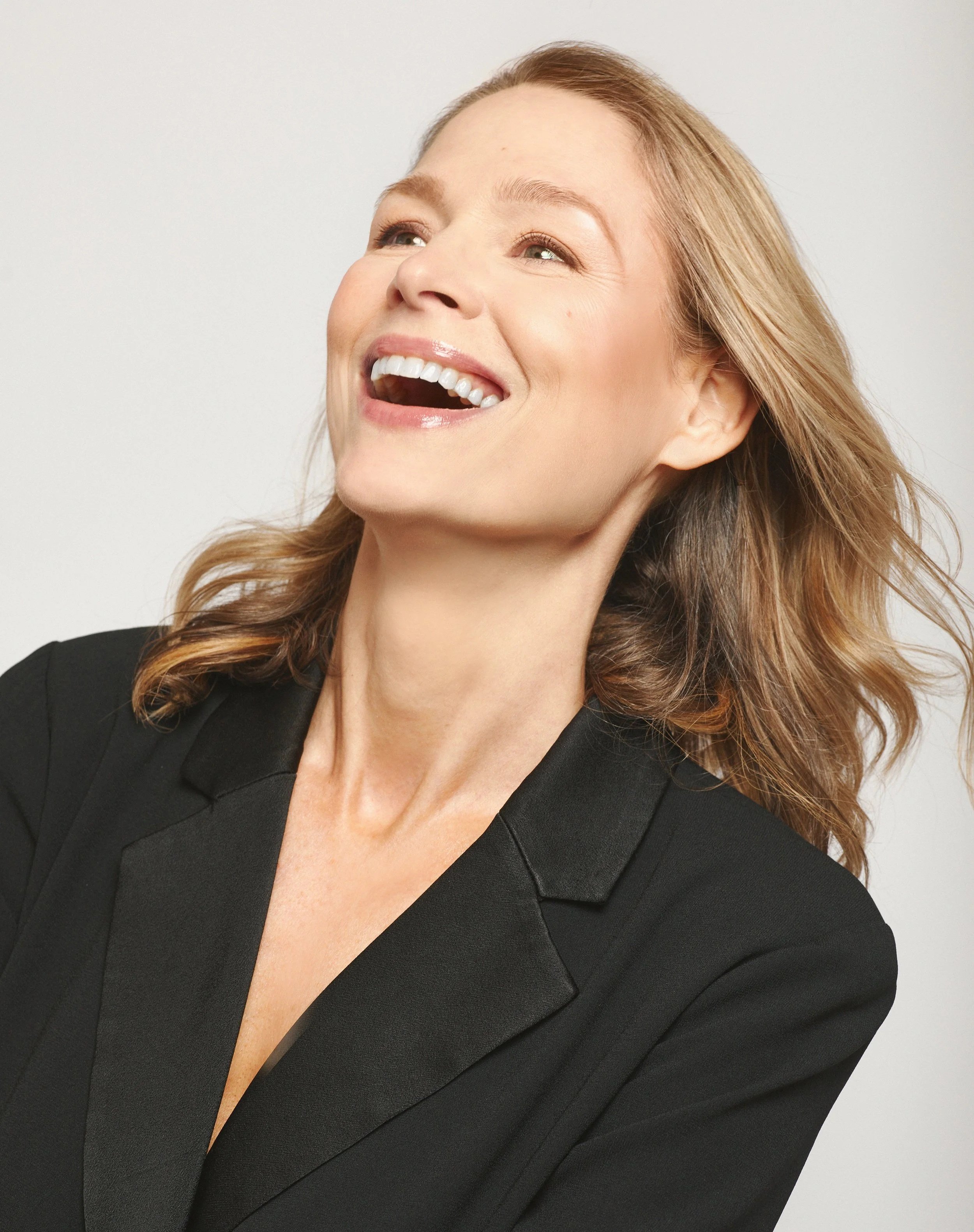 Cherie Mendez laughing, wearing a black blazer.