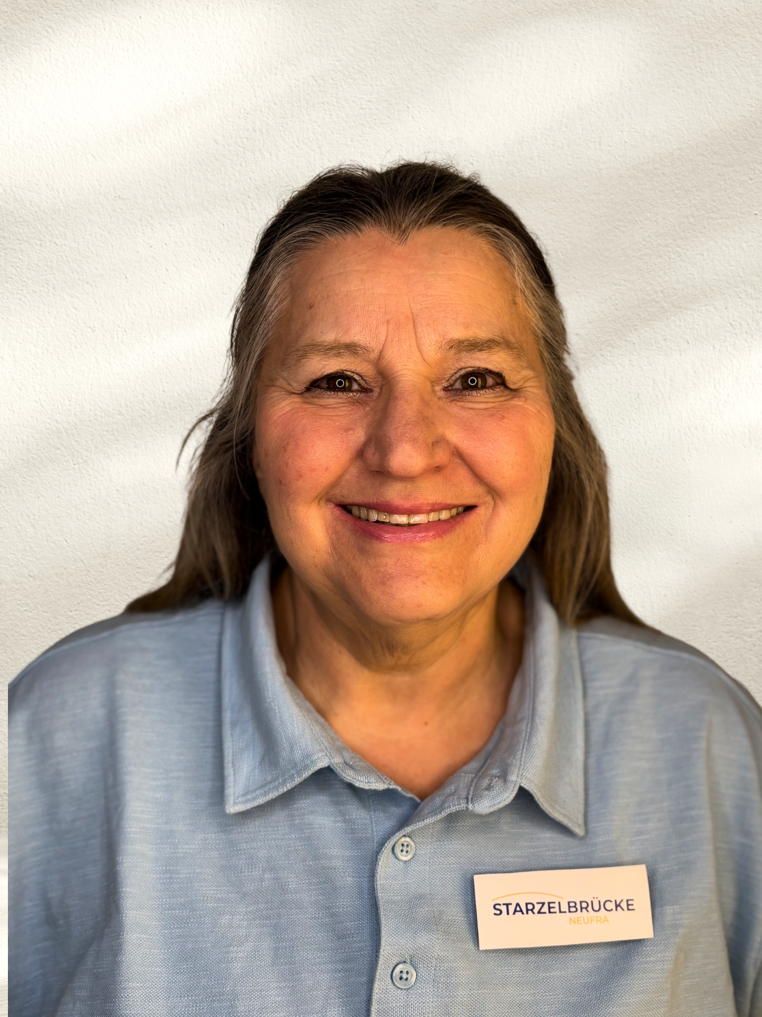 Illustration einer Frau mit grau schulterlangen Haaren und ohne Gesicht, trägt ein weißes Oberteil.