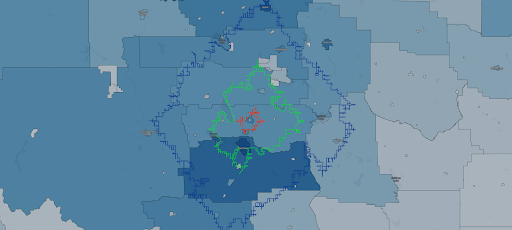 Color-coded map featuring various shades of green, blue, and red, with an irregular boundary in blue around the central area.
