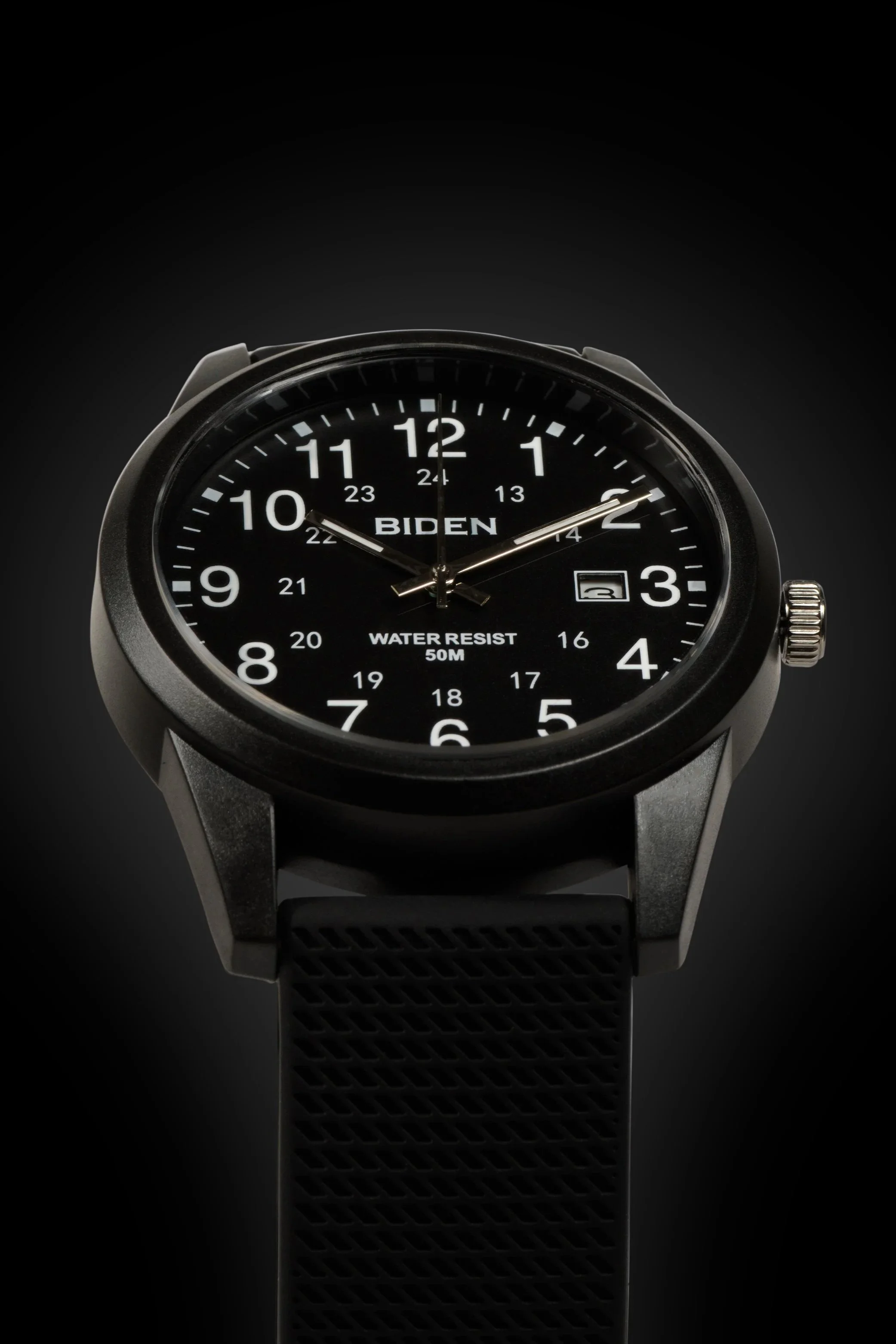 A wristwatch with a black dial, white numerals, and the name 'BIDEN' on the face, showing the time as 10:09:07, with a date window displaying the number 3.
