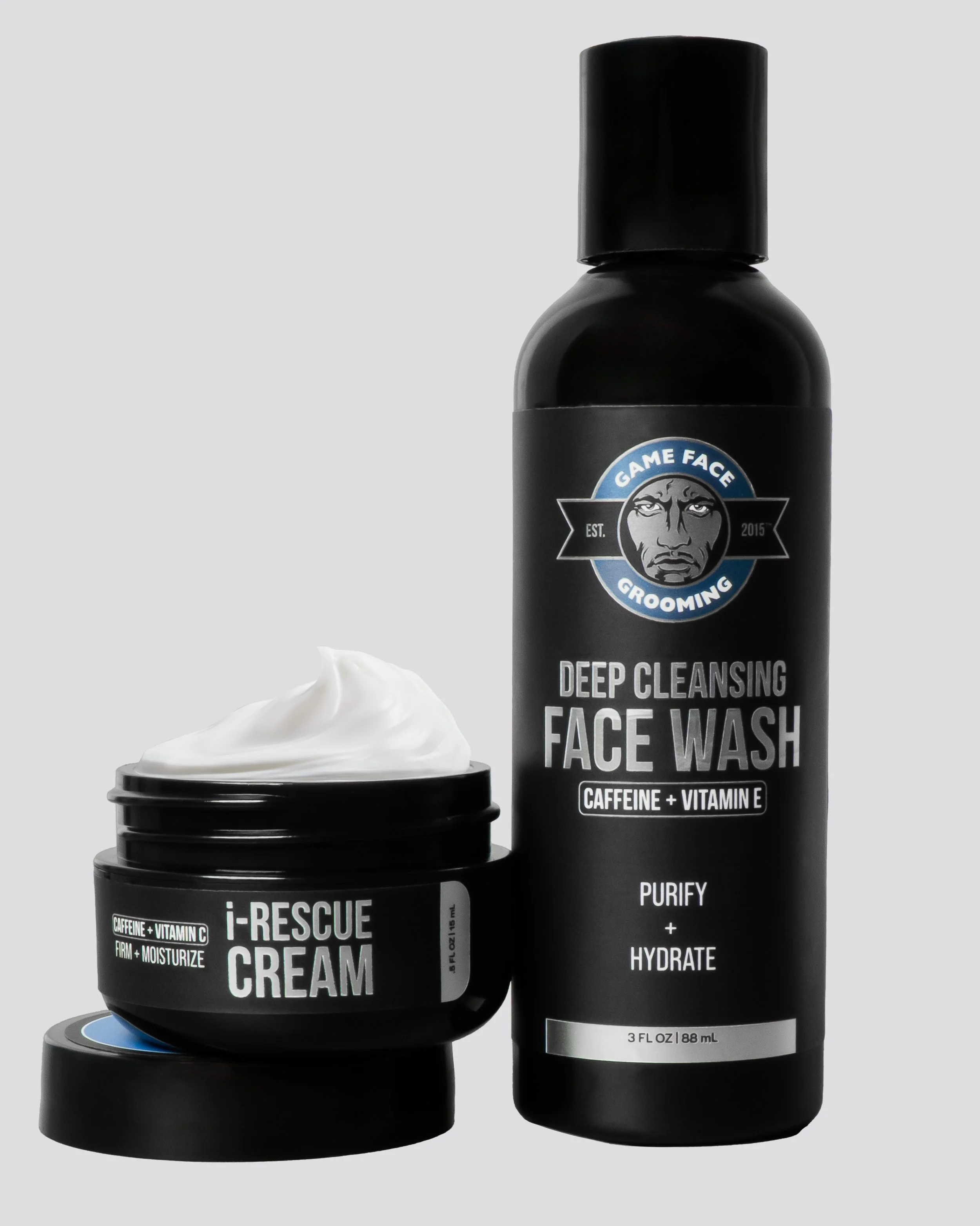 Two black bottles of skincare products with white labels and a small white cream in a black jar, set against a light gray background.