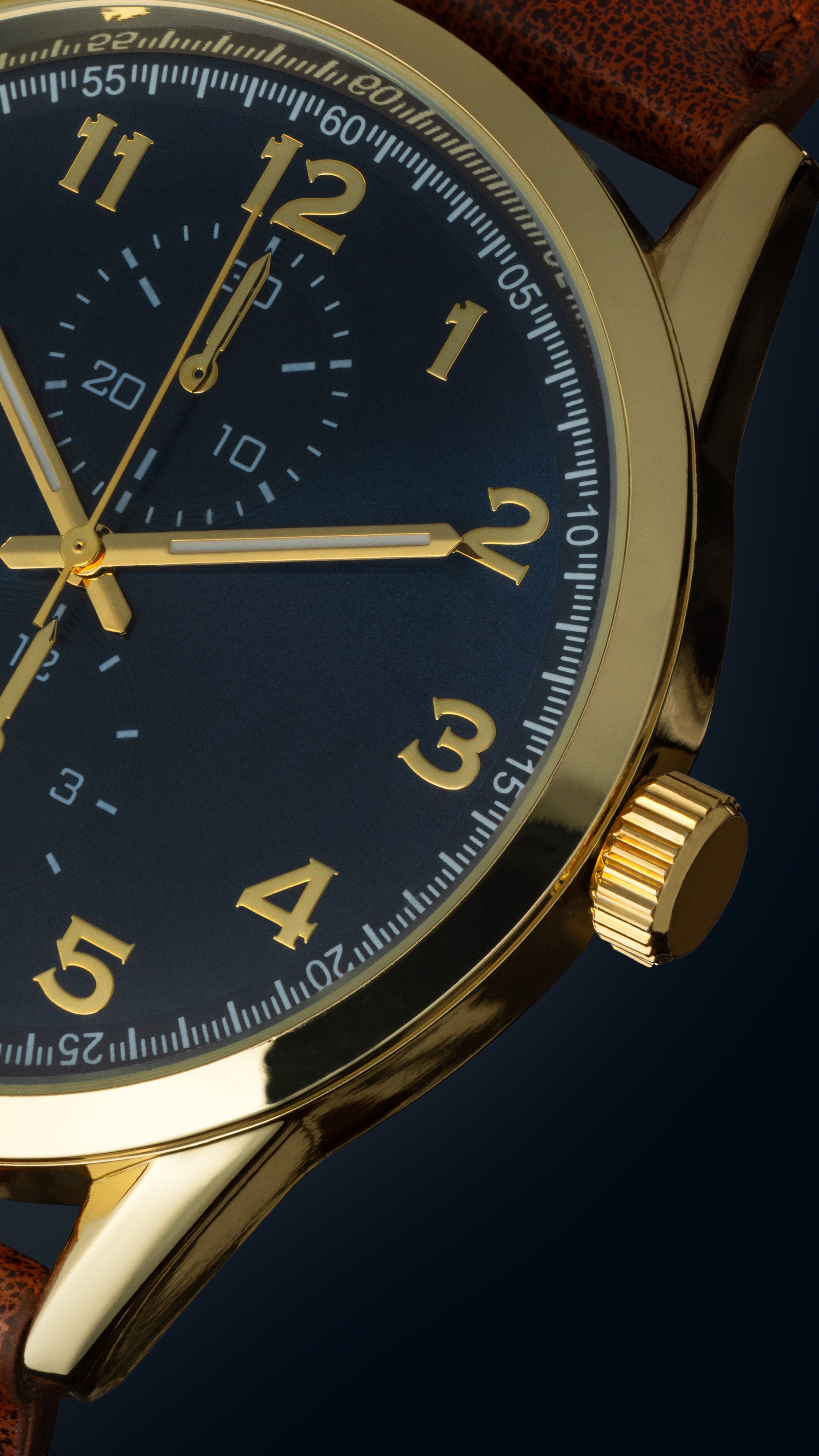Close-up of a gold wristwatch with a dark face, gold numerals, and a leather strap.