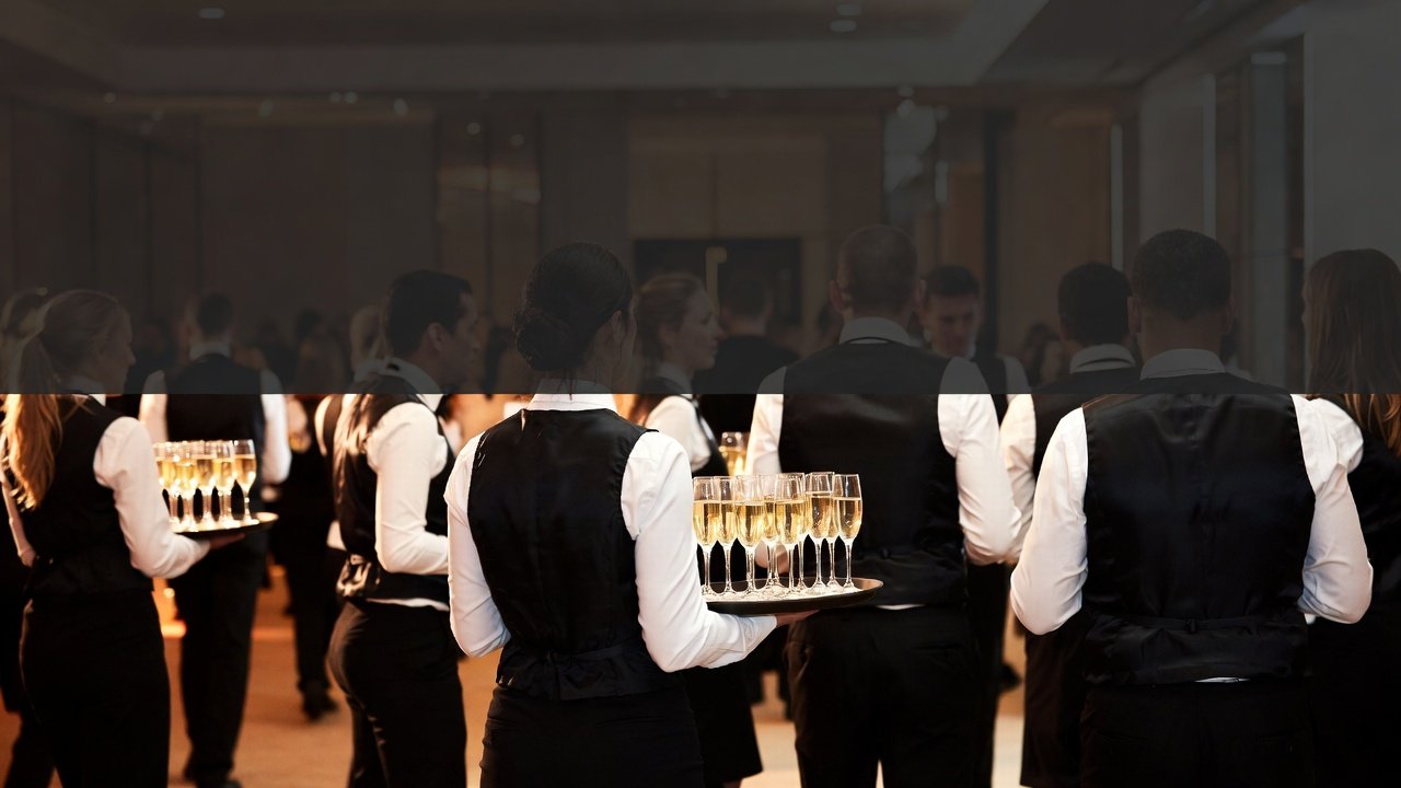 Hotel or event staff serving champagne at a formal gathering or reception