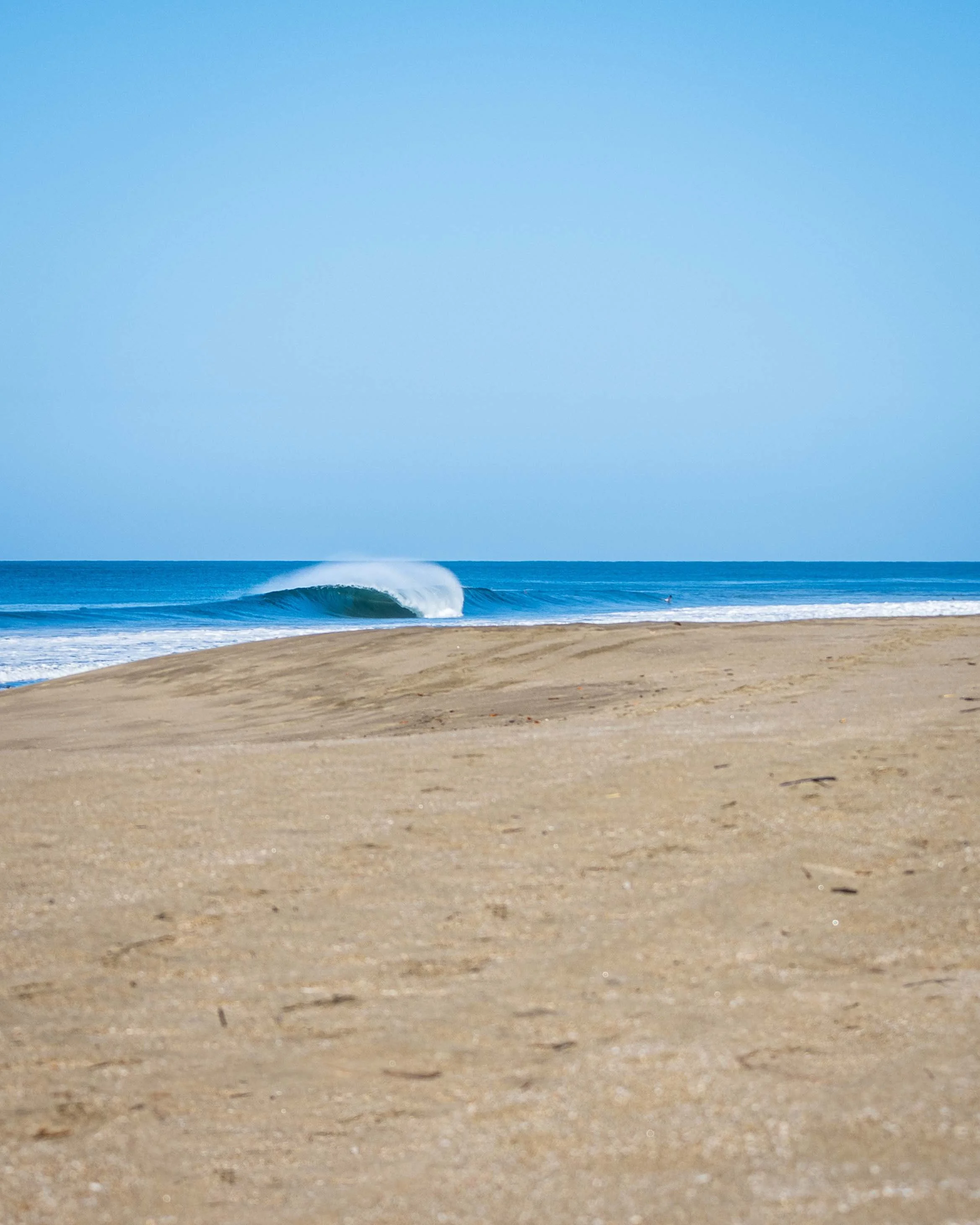 Empty beach with sand and ocean waves