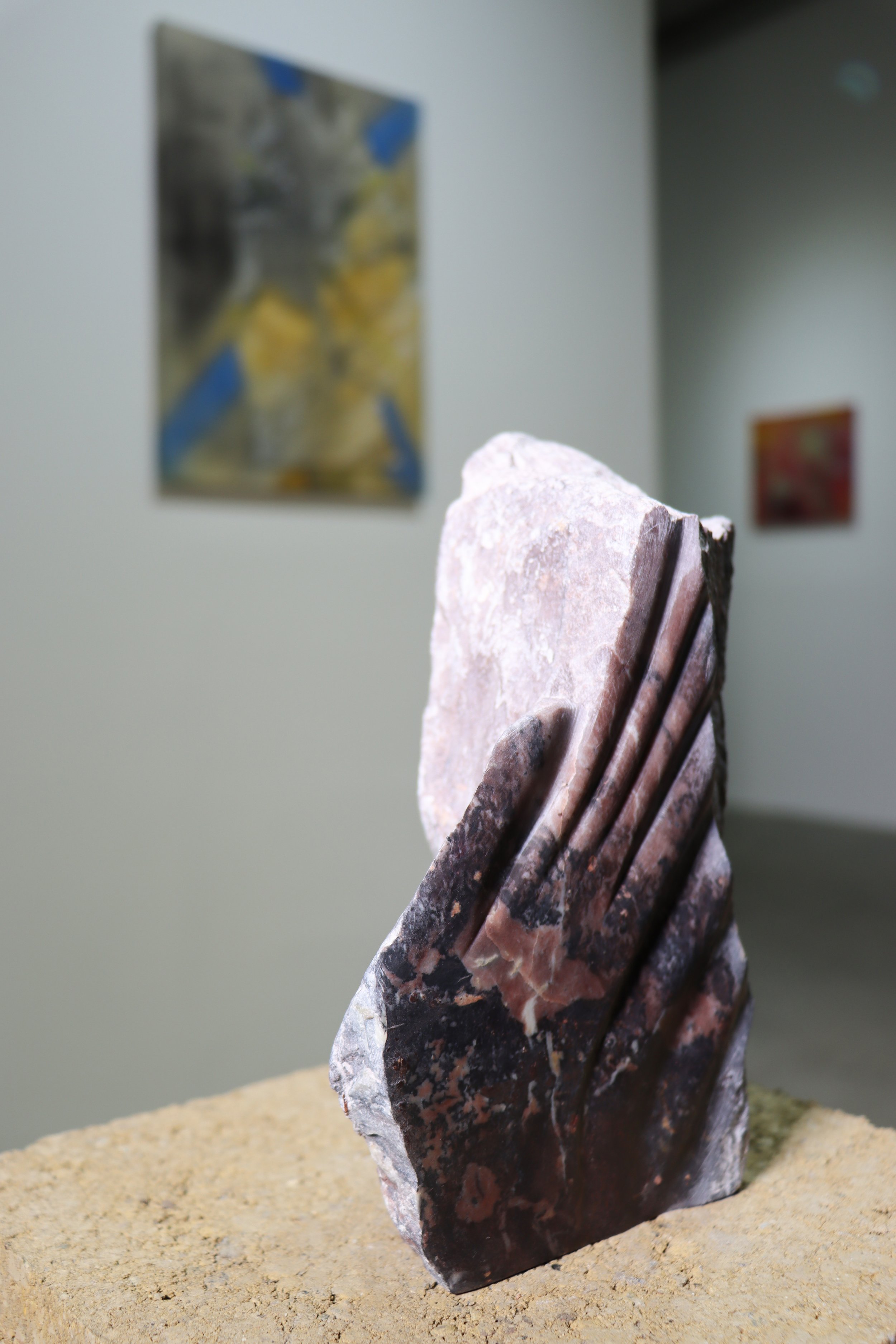 NOT YET SENT OR EDITED_Purple stirred in the distance, light-vein on a cusp, 2025-26, Soapstone, earth, pine pedestal, ~ 9” X 6” X 5” close up in install iii. jpg.jpg