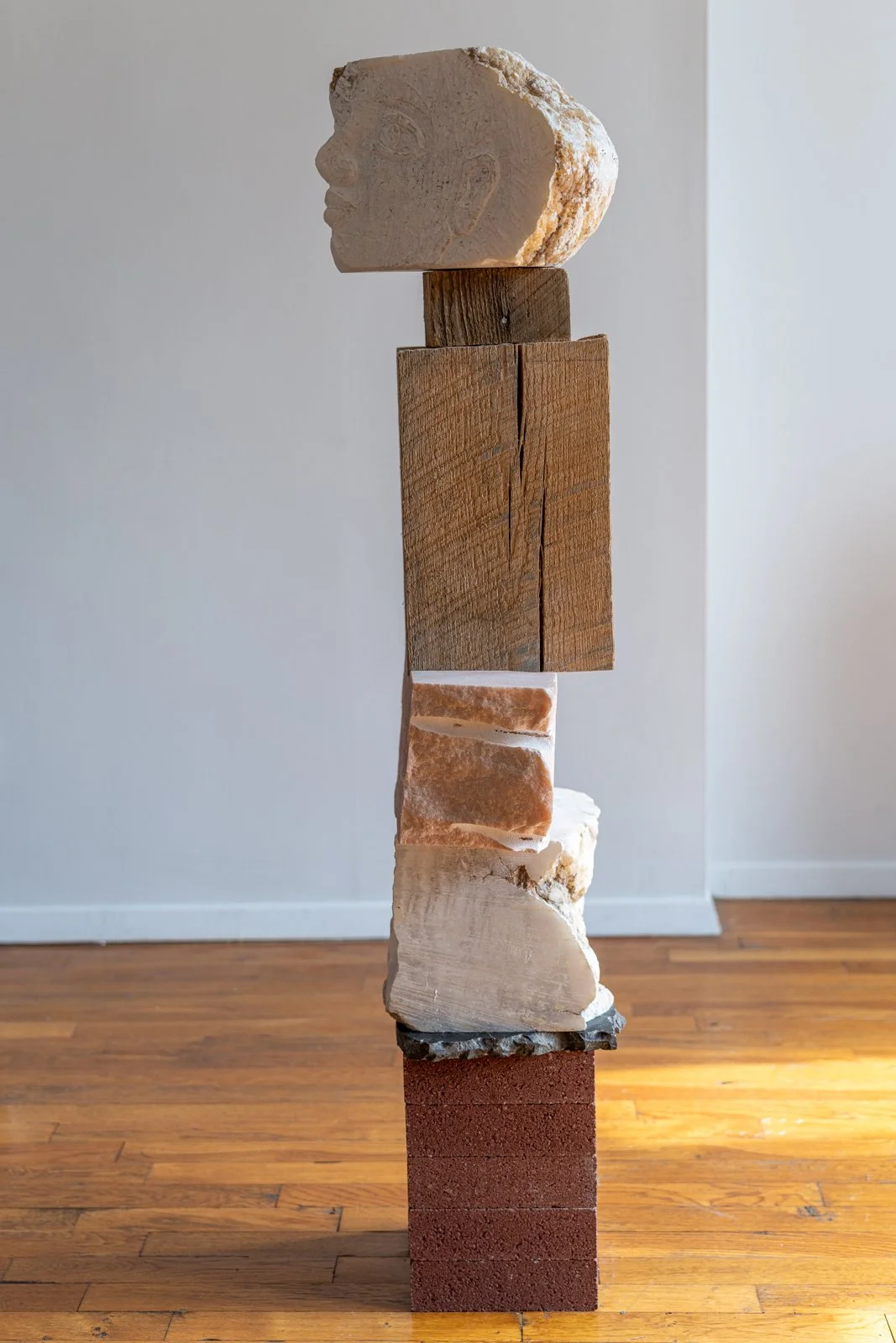 I Searched For You Inside Homes And On Endless Roads (Faces), 2024, Alabaster, earth, found wood, marble, brick, 50” X 12.5” X 9.5"

Photo credit: Benjamin Koditschek